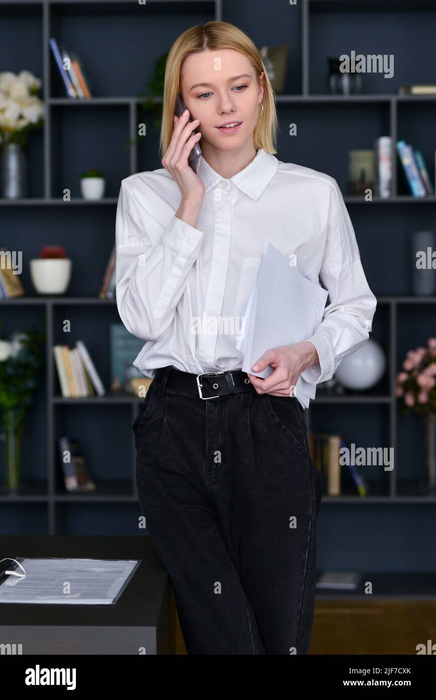 Frau telefoniert im Büro. Stockfoto