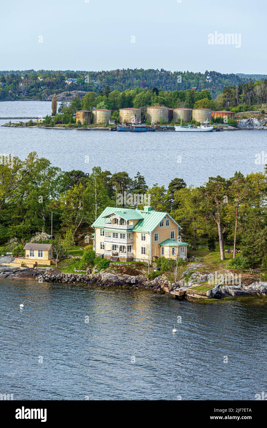 Ein Anwesen am Wasser auf einer der vielen Inseln des Stockholmer Archipels - hier Granholmen, Schweden. Hinter dem Stora Hog befinden sich alte Öllagertanks Stockfoto