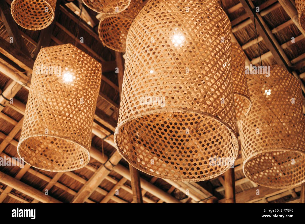 Hängende handgewebte Bambuskörbe unter dem cogon-Dach, hergestellt in Licht- oder Lampenschirmen zur Dekoration und zum Ambiente. Selektiver Fokus. Stockfoto