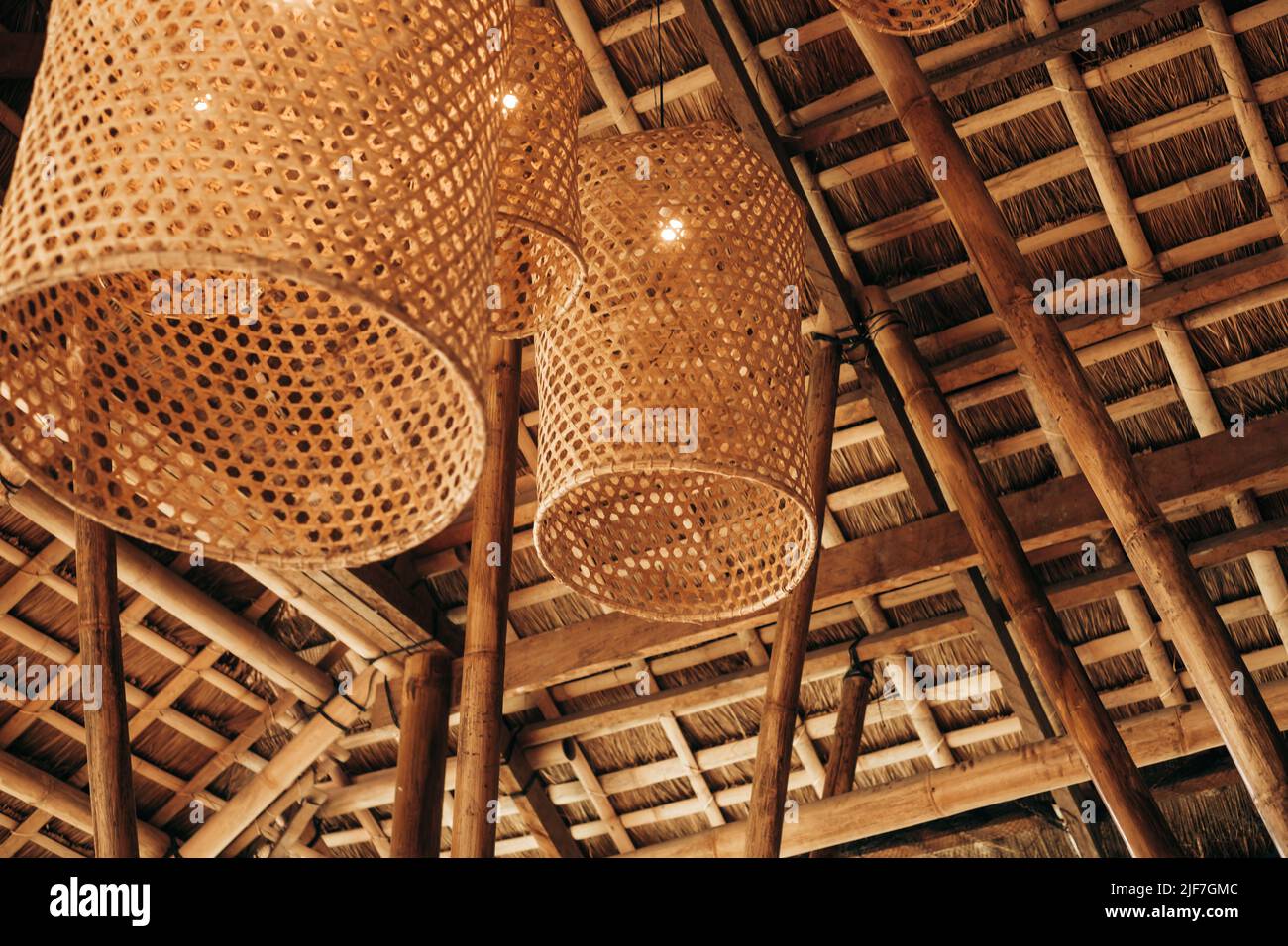 Hängende handgewebte Bambuskörbe unter dem cogon-Dach, hergestellt in Licht- oder Lampenschirmen zur Dekoration und zum Ambiente. Selektiver Fokus. Stockfoto