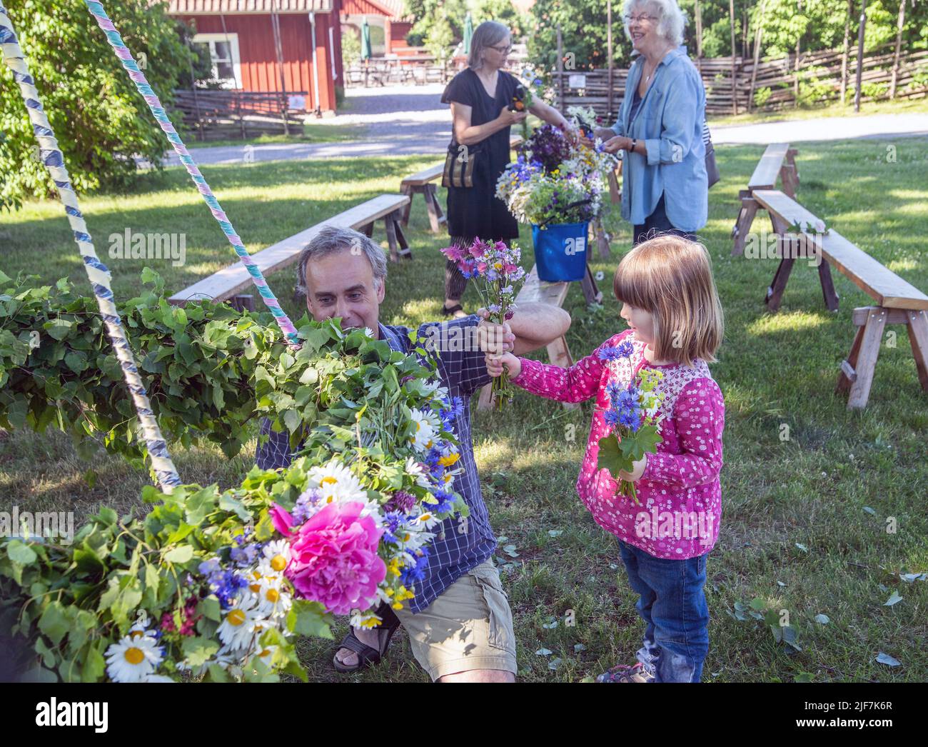 Mittsommer in Schweden binden Eltern und Kinder Blumen auf einem großen Kranz in malmkoping, Schweden Stockfoto