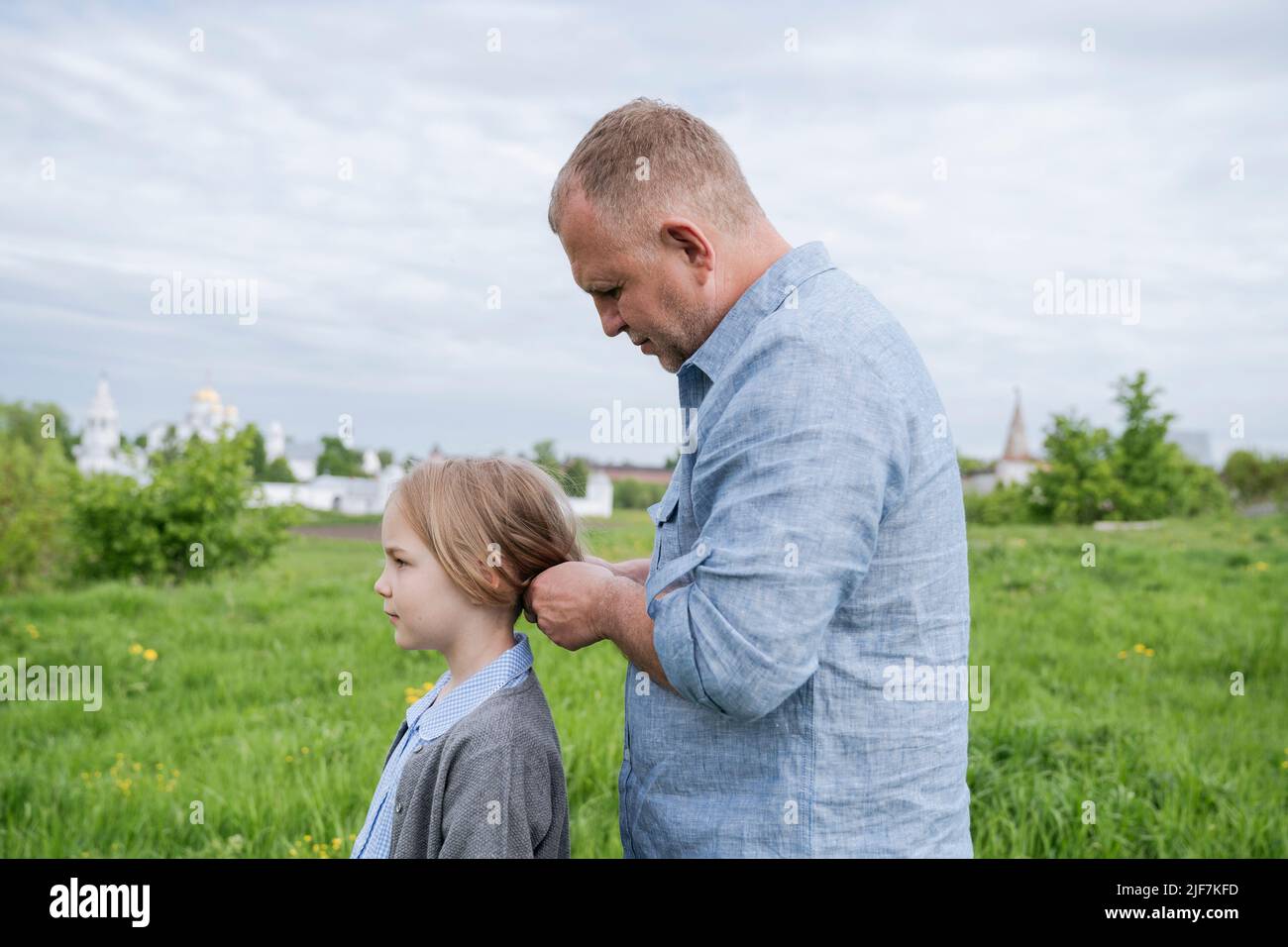 Ein Vater hält die Haare seiner Tochter für einen Spaziergang. Stockfoto
