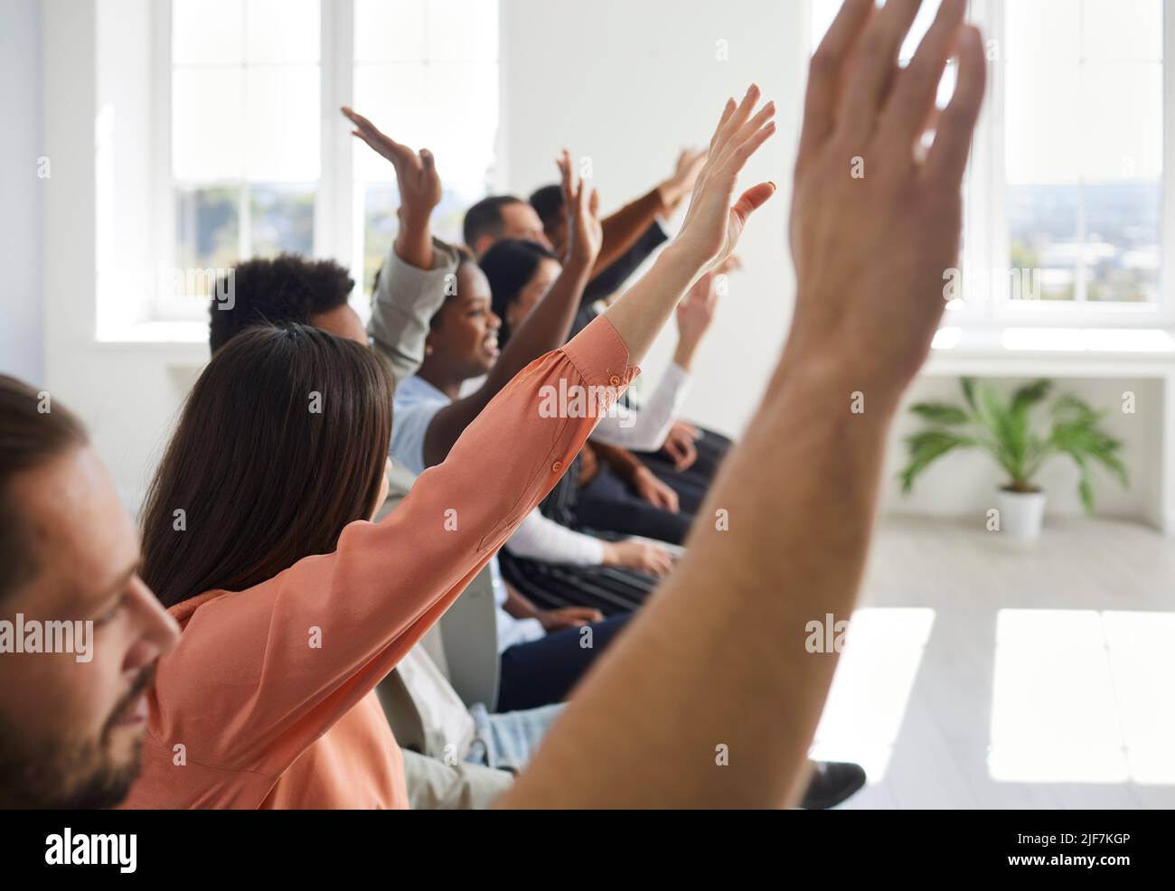 Fröhliches junges Publikum, das nach dem Vortrag die Hände hebt und Fragen an den Redner stellt Stockfoto Fröhliches junges Publikum, das nach dem Vortrag die Hände hebt und Fragen an den Redner stellt Stockfoto