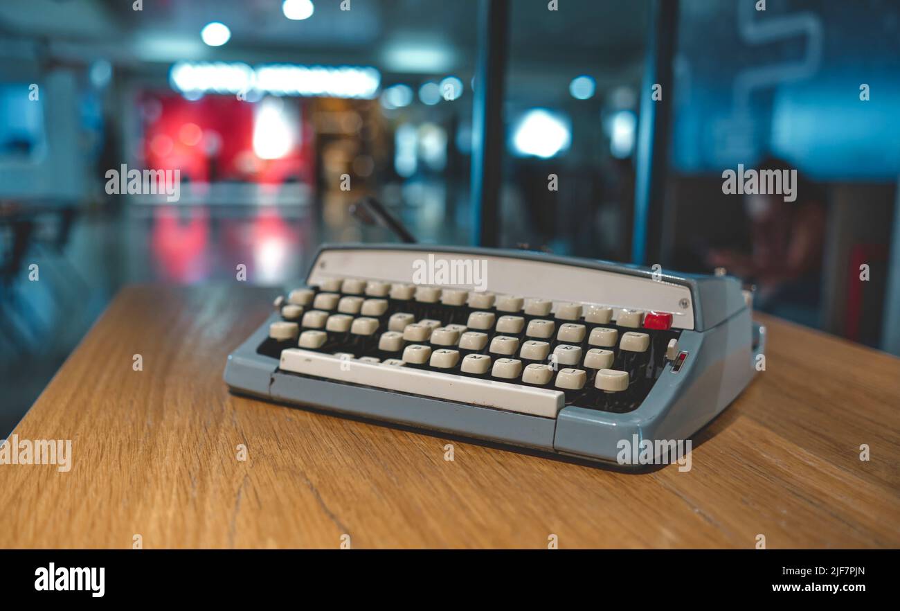 Retro alte Schreibmaschine auf verwackelte Hintergrund und vor Holztisch. Vintage-Konzept. Stockfoto