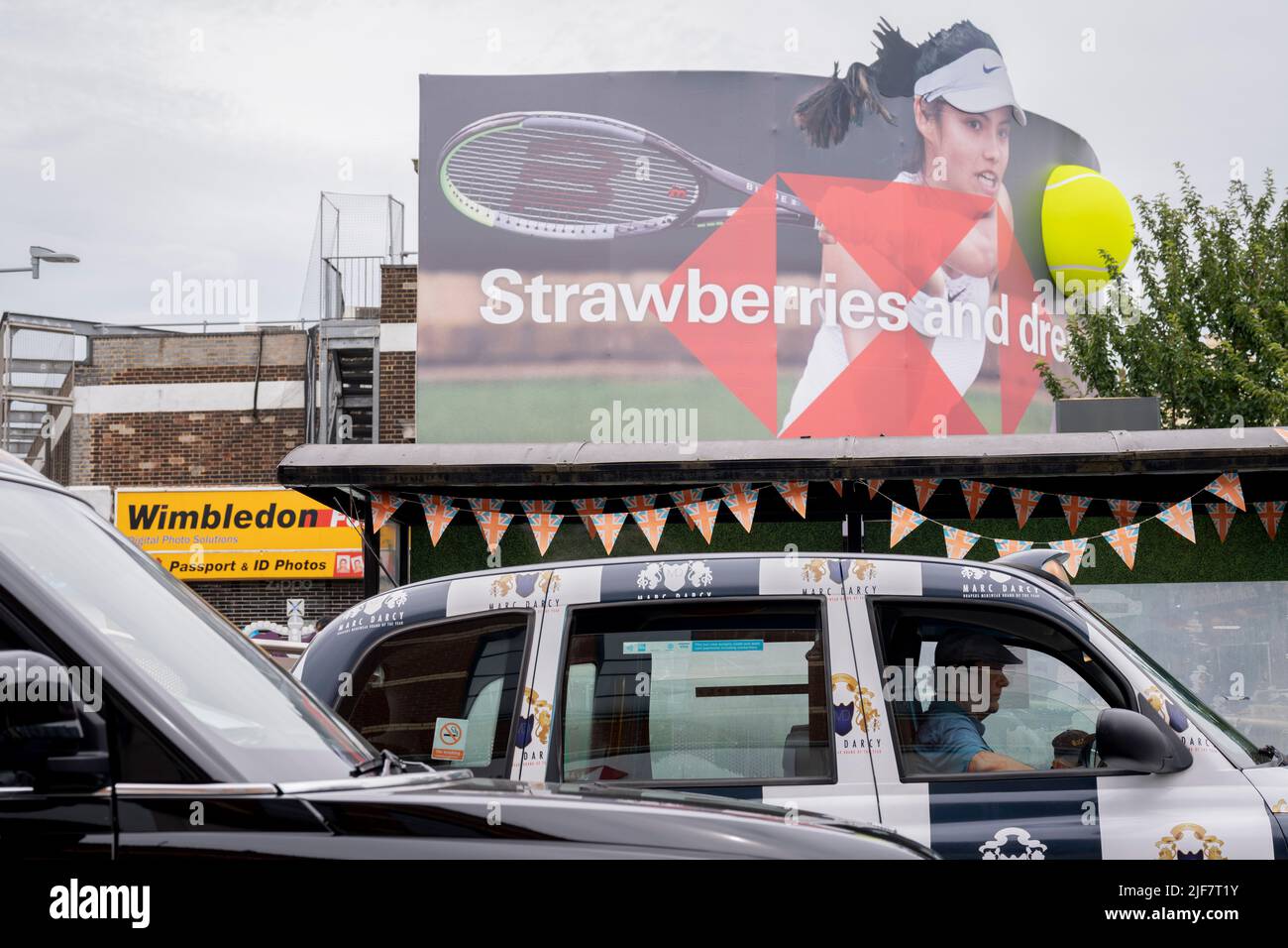 Die britische Tennisspielerin Emma Raducanu, die von HSBC gesponsert wird, erscheint in der ersten Wettkampfwoche der Wimbledon Lawn Tennis Association Championships am 30.. Juni 2022 in London, England, auf einer riesigen Plakatwand im Stadtzentrum von Wimbledon. Raducanu, dessen Eltern beide in der Finanzbranche tätig sind, hat bereits Sponsorenverträge mit Porsche, Tiffany and Co, British Airways, Evian, Dior und Vodafone. HSBC ist auch ein wichtiger Wimbledon-Sponsor, aber eine britische Parlamentsgruppe hat Wimbledon aufgefordert, die Marke über die Unterstützung der Bank für das umstrittene nationale Sicherheitsgesetz in Hongkong fallen zu lassen Stockfoto