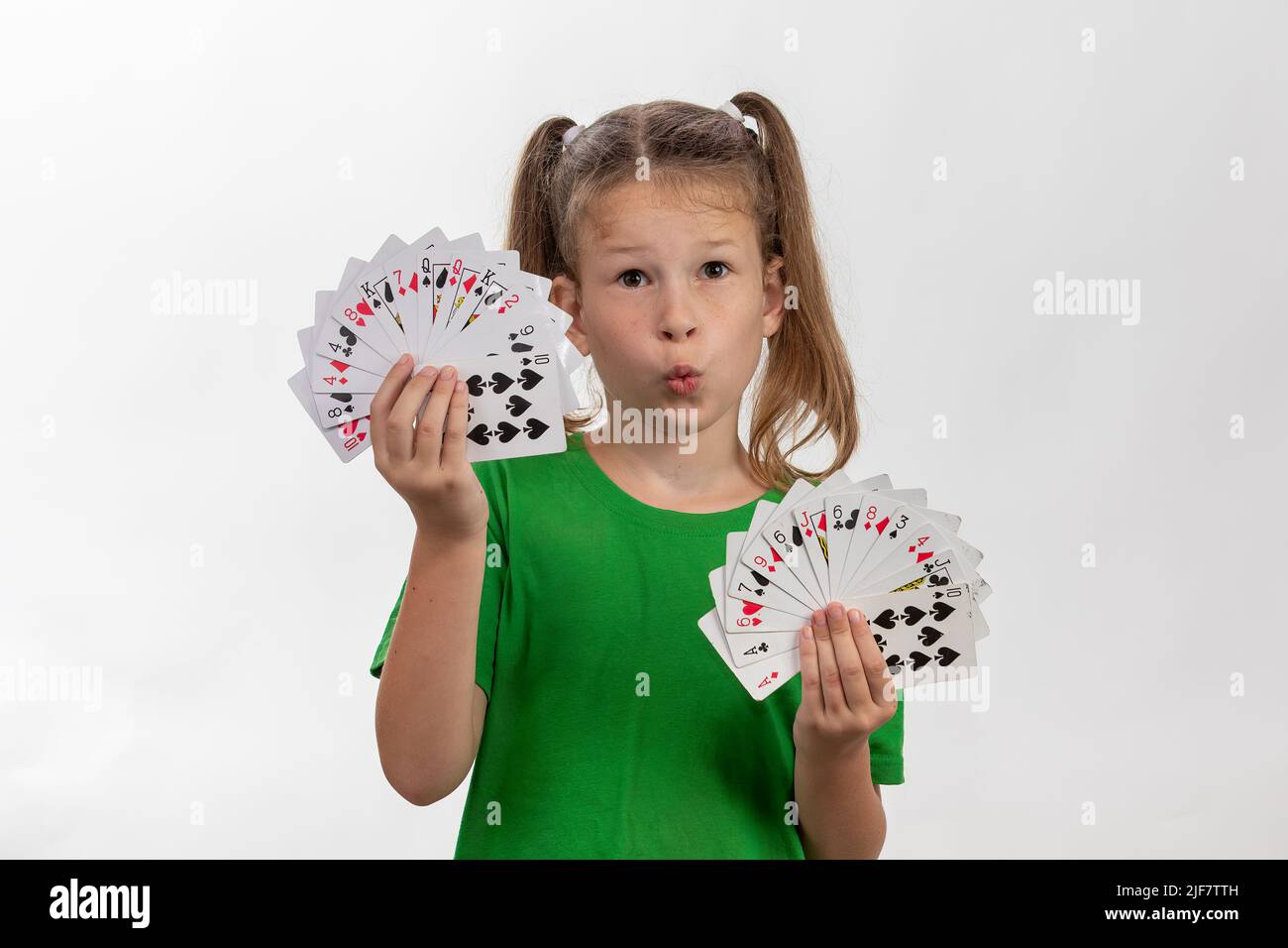 Nahaufnahme Porträt von kaukasischen Mädchen mit Spielkarten. Isoliert auf weißem Hintergrund. Konzept für die Kindheit. Freizeit, Spaß, Hobby, Mädchen Zauberer. Stockfoto