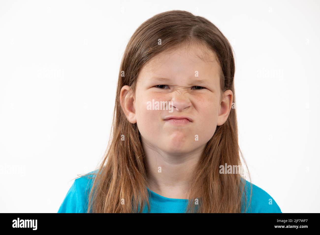 Natürliches Porträt eines mürrischen Kindes - Mädchen, das versucht, lustig zu sein Stockfoto