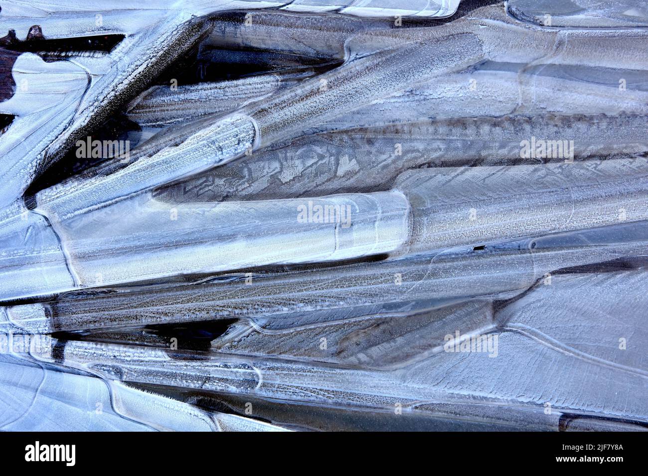 Schwarz-weiß frostigen Muster auf der Oberfläche der gefrorenen Pfütze, Textur für den Hintergrund. Stockfoto