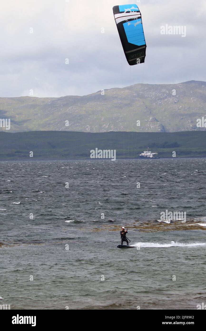 Kitesurfer, Kiteboarding oder Kitesurfen, eine Sportart, bei der Windkraft mit einem großen Power Kite eingesetzt wird.vor Ganavan Sands in der Nähe von Oban, Schottland. Stockfoto