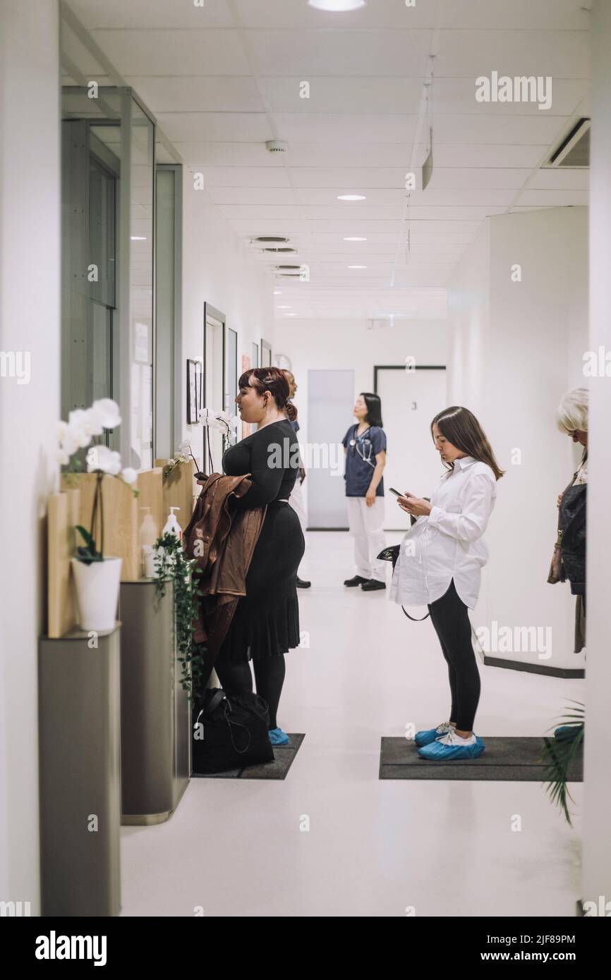 Volle Seitenansicht von Patientinnen, die im Krankenhaus Schlange stehen Stockfoto