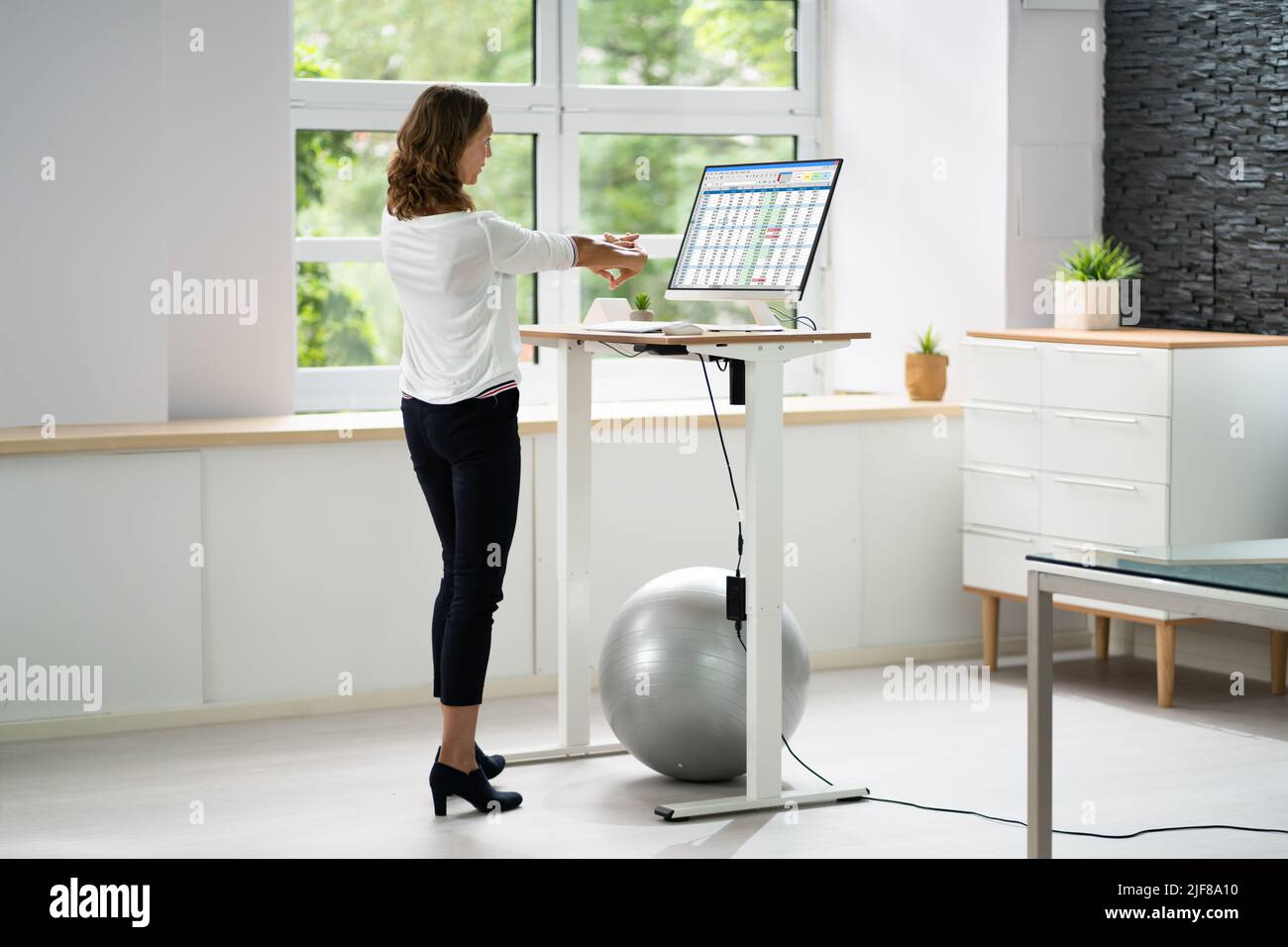 Übung Zum Dehnen Der Mitarbeiter Am Schreibtisch Im Büro Stockfoto