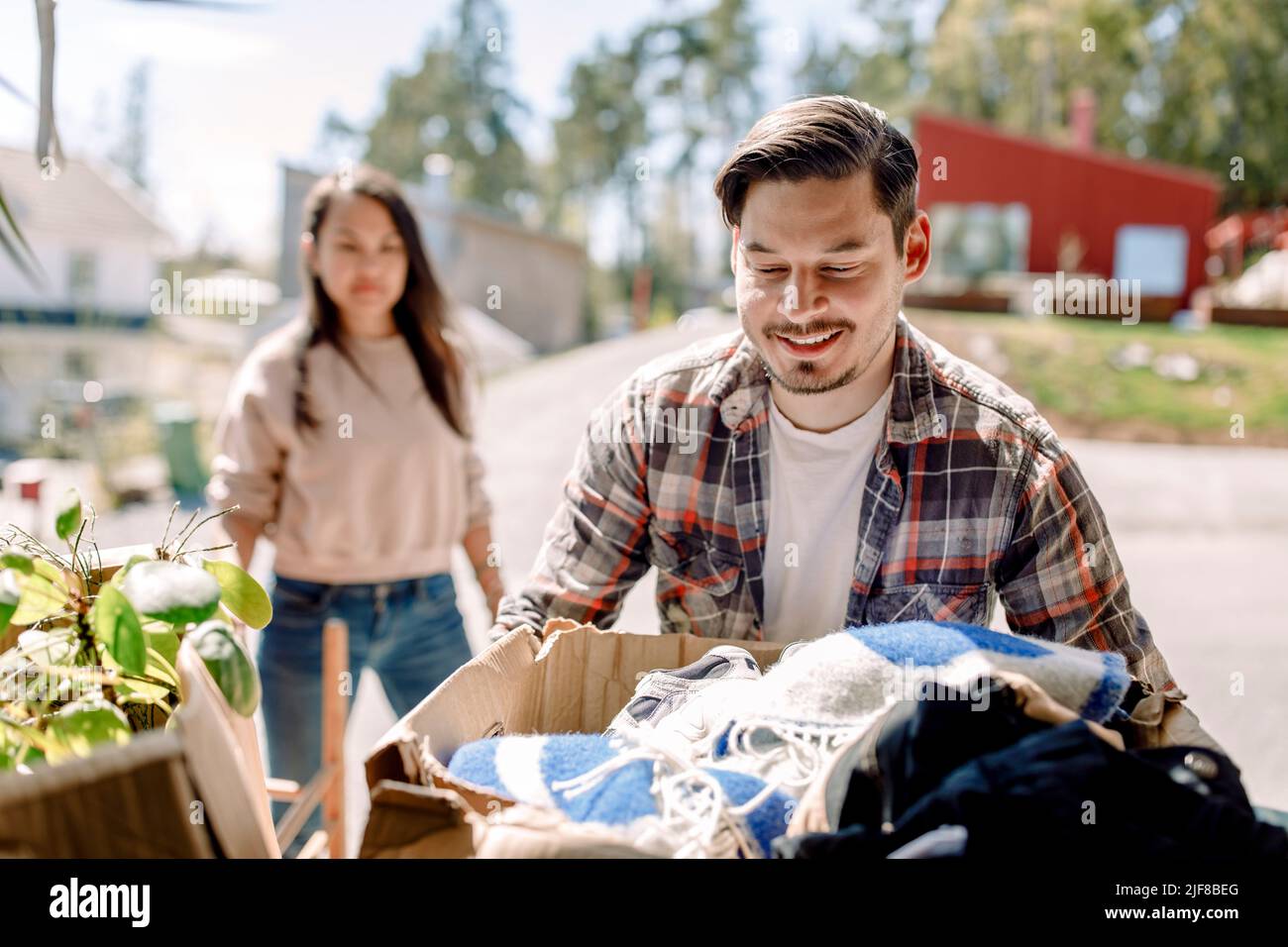 Mann, der Pappkarton trägt, während er im neuen Haus umzieht Stockfoto