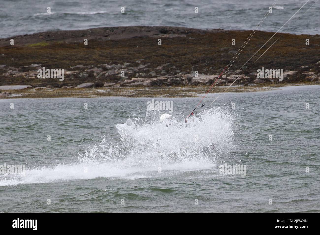 Kitesurfer, Kiteboarding oder Kitesurfen, eine Sportart, bei der Windkraft mit einem großen Power Kite eingesetzt wird.vor Ganavan Sands in der Nähe von Oban, Schottland. Stockfoto