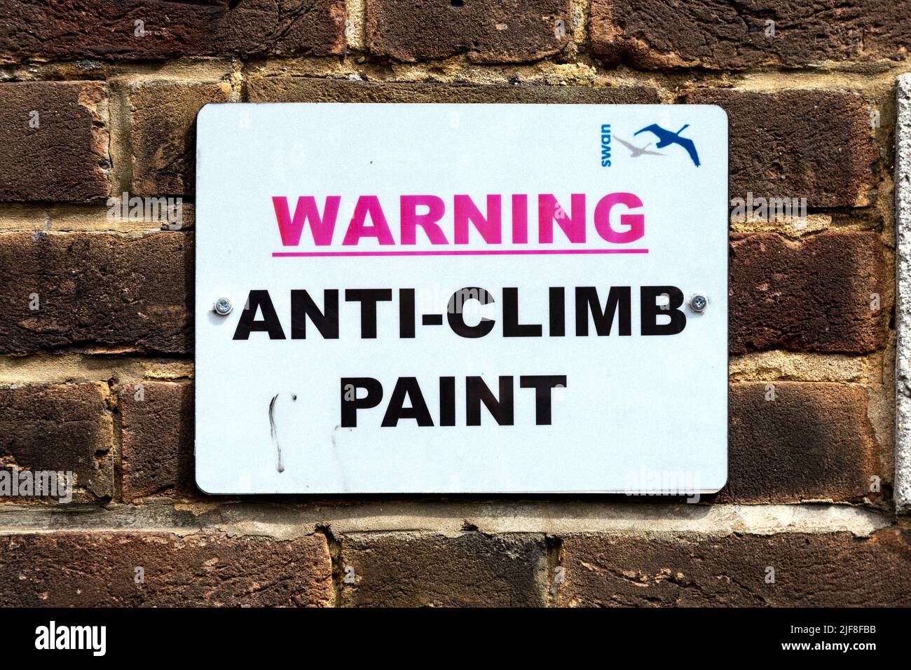 Warnschild Anti-Climb Farbe auf einer Ziegelwand Stockfoto