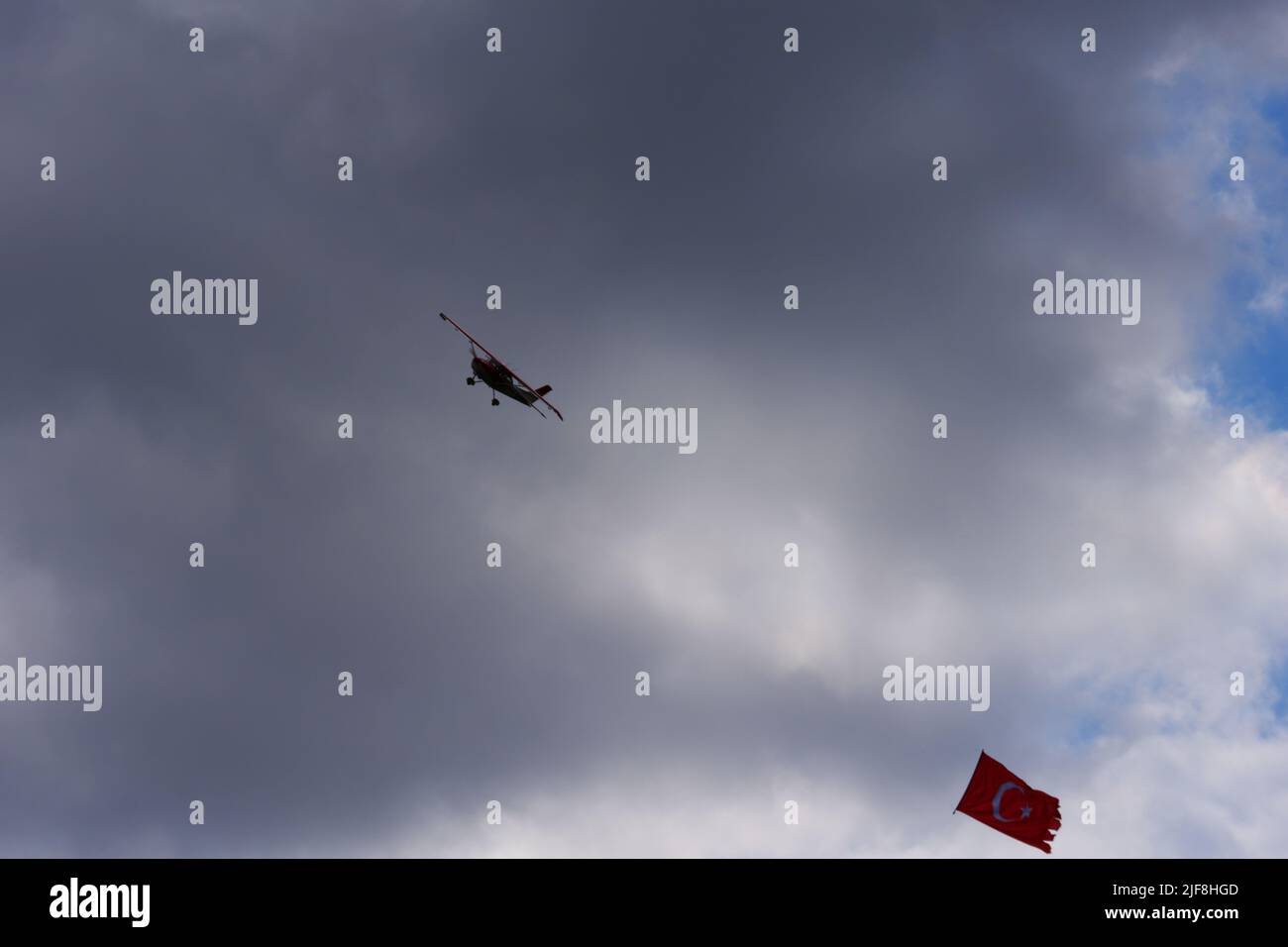 Modellflugzeug mit türkischer Flagge in einer Flugschau, die in dunklen Wolken fliegt Stockfoto