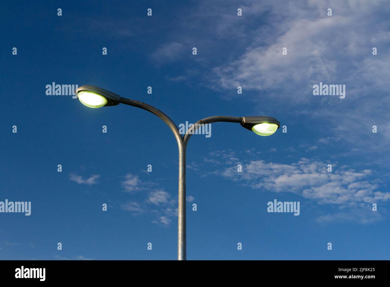 Ein Straßenlicht, das von einem einzigen aufrechten Pol aus gepaart wurde. Stockfoto