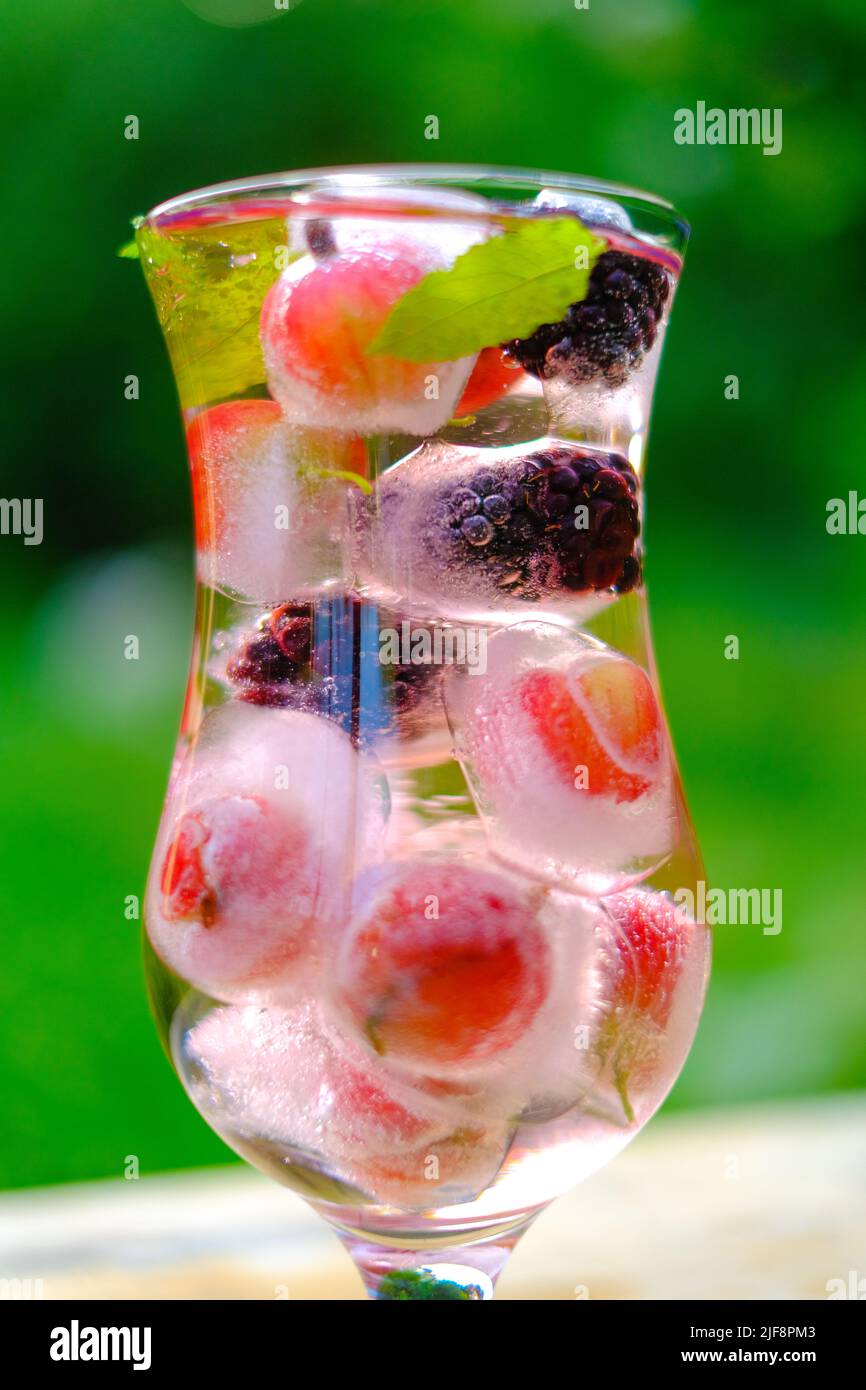 Beerencocktail.Mineralwasser mit Beeren und Eis.erfrischendes Getränk im Sommer.Cocktail mit Stachelbeeren und Brombeeren, Minze und Eiswürfeln im Sommer Stockfotografie