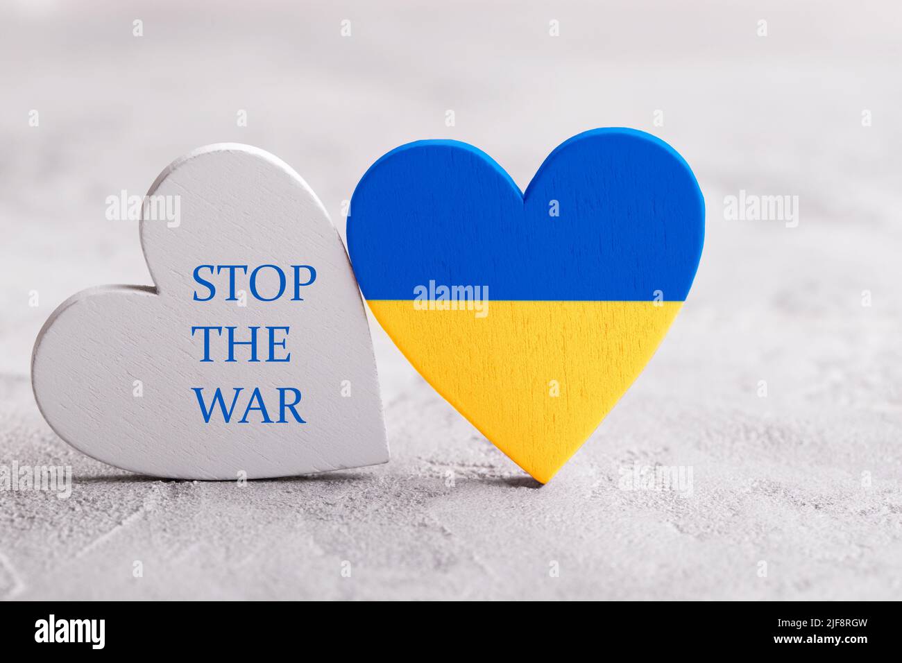 Herz mit ukrainischen Flaggen Farben auf dem grauen Stein Hintergrund. Beendet den Krieg in der Ukraine Stockfoto