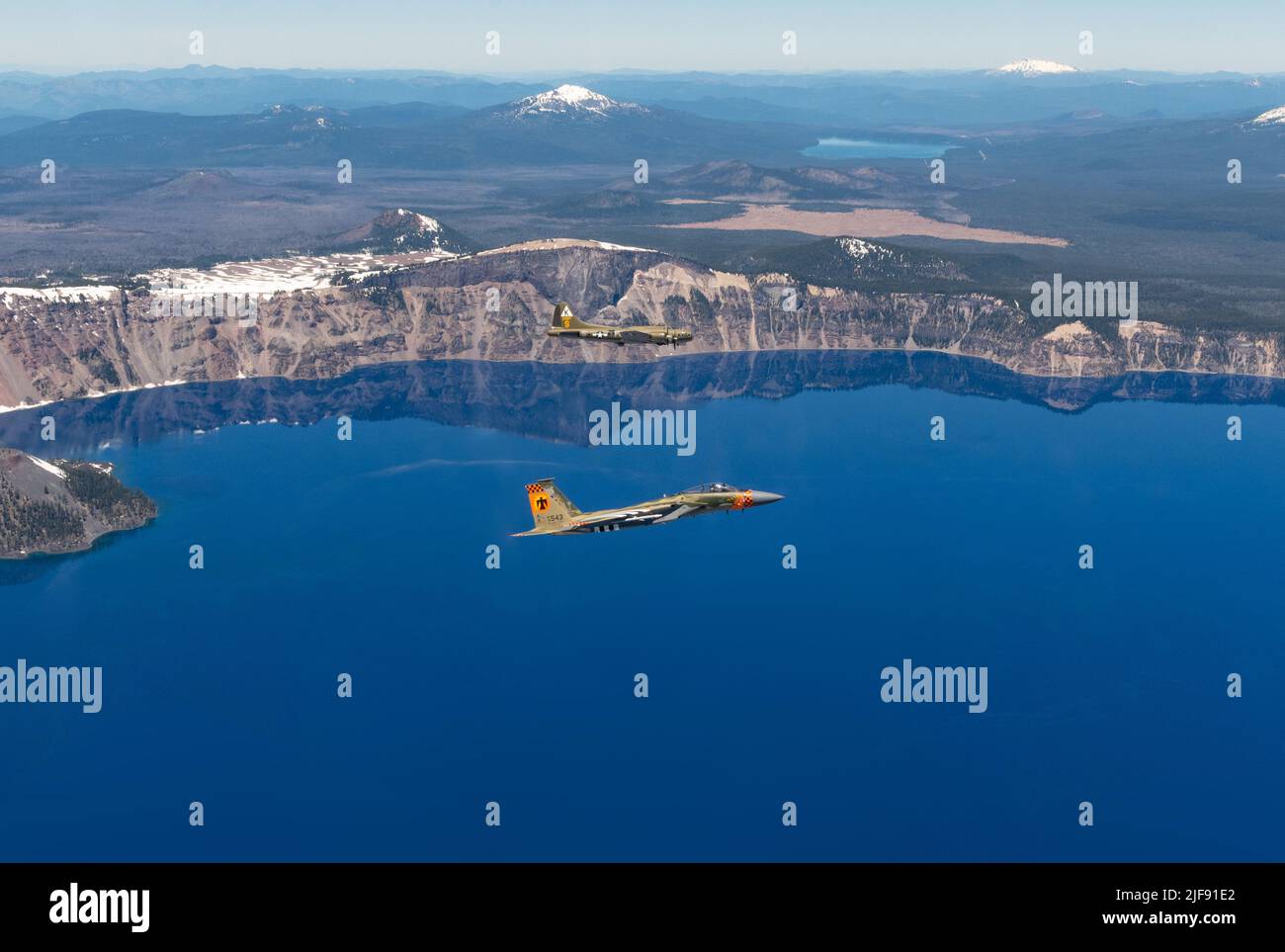 Ein F-15 Adler der US-Luftwaffe aus dem 173. Fighter Wing mit einer Lackierung zum Gedenken an den Namensgeber von Kingsley Field, LT. David R. Kingsley, fliegt in Formation mit einer B-17 Flying Fortress über Crater Lake, Oregon, während des Sentry Eagle 2022, Juni 24. Kingsley war bombardier auf einer B-17 während des Krieges und opferte sein Leben, um weitere Besatzungsmitglieder zu retten und erhielt anschließend die Ehrenmedaille. (USA Foto der Air National Guard von Staff Sgt. Penny Snoozy) Stockfoto