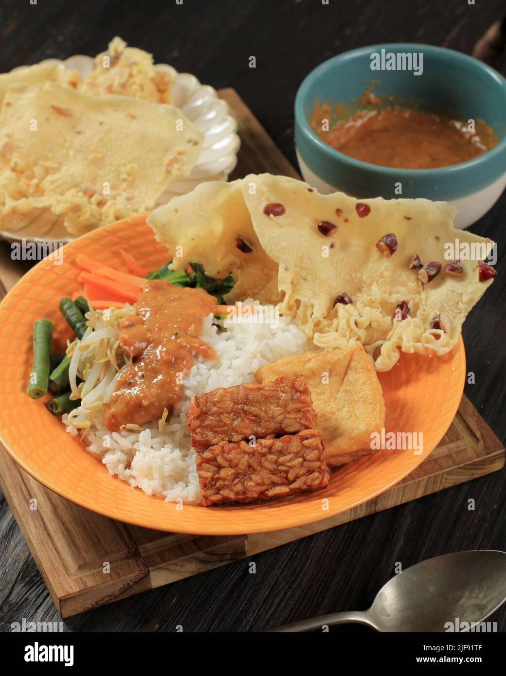 Nasi Pecel, traditionelles indonesisches Menü mit würziger Erdnusssauce, Tempeh, gekochtem Gemüse und gebratenen Tofu, Rempeyek, Beliebt für Frühstück, Abendessen, OP Stockfoto