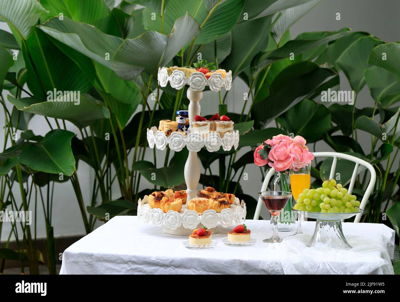Garden High Tea Party mit Tee, Kuchen, Keksen und Obst Stockfoto
