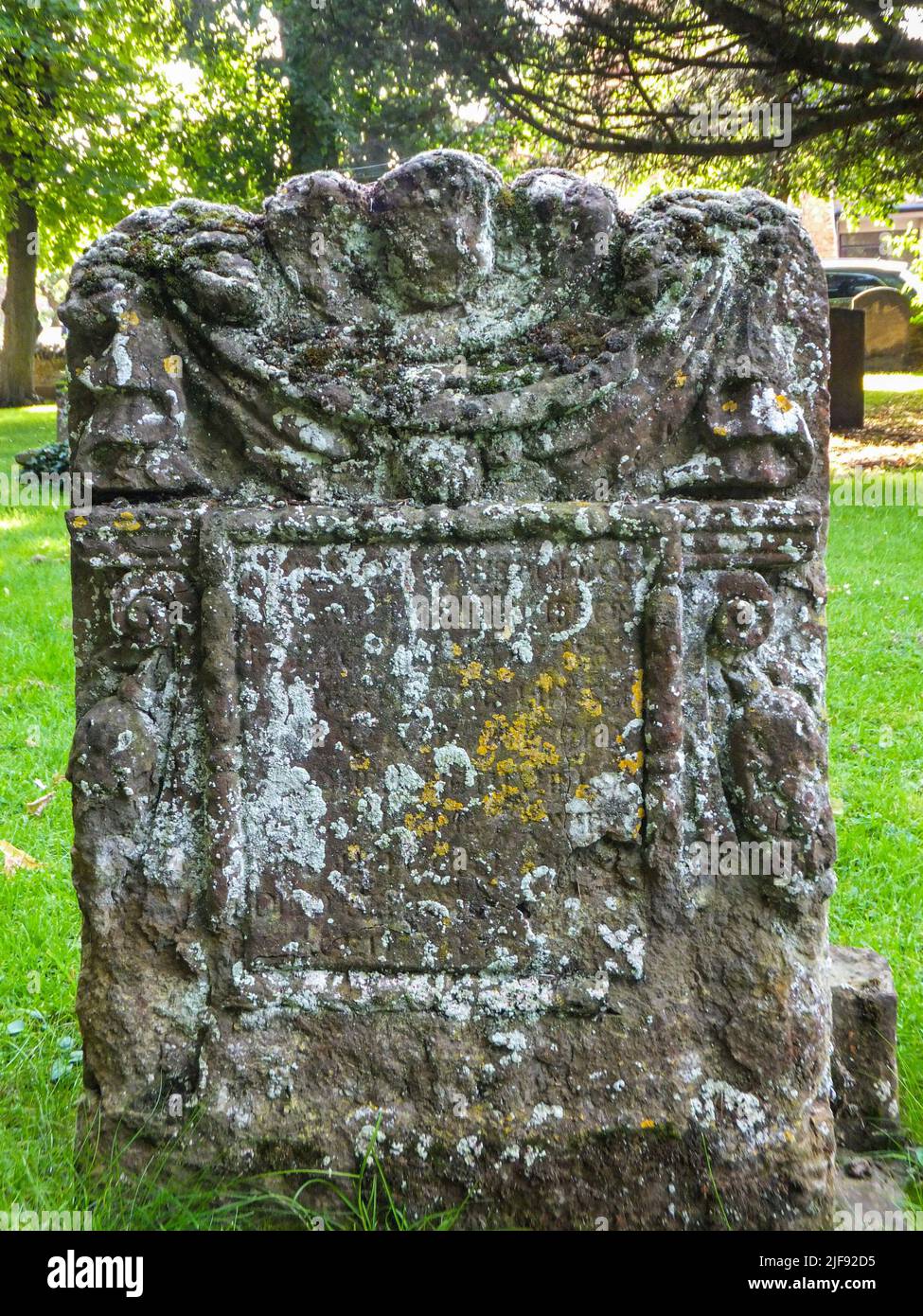 Ein alter verwitterter Grabstein auf einem Friedhof in Usk, Monmouthshire, Wales, Großbritannien. Stockfoto