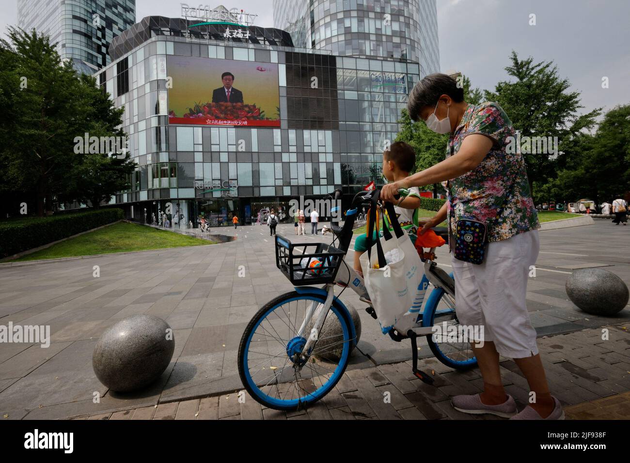Auf einem Bildschirm wird die Rede des neuen Chefs von Hongkong, John Lee, während einer Zeremonie zur Einweihung der neuen Regierung der Stadt in einem Einkaufszentrum in Peking, China, am 1. Juli 2022, zum 25.. Jahrestag der Übergabe der Stadt von Großbritannien an China, gezeigt. REUTERS/Thomas Peter Stockfoto