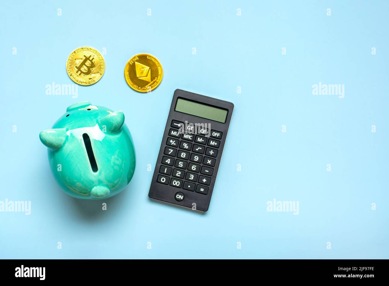 Sparschwein, Rechner und Münzen aus goldenem Bitcoin, Ethereum isoliert auf blauem Hintergrund Akkumulation von Kryptowährung, Investitionen in Krypto-Markt, Geschäftskonzept Draufsicht Flat Lay. Stockfoto