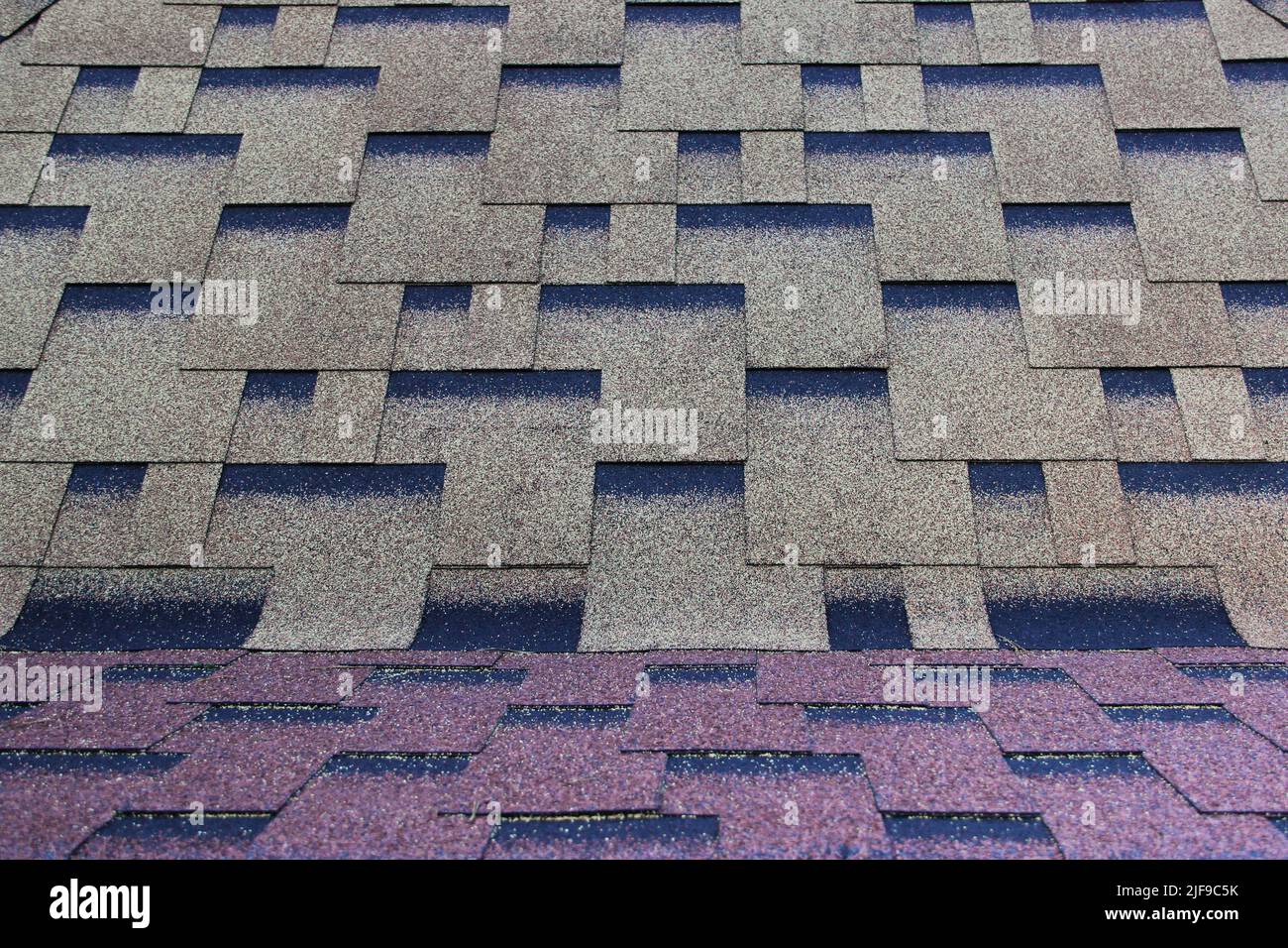 Asphaltdach in einem symmetrischen Muster. Verbundschindeln. Sich wiederholende Kachel. Stockfoto