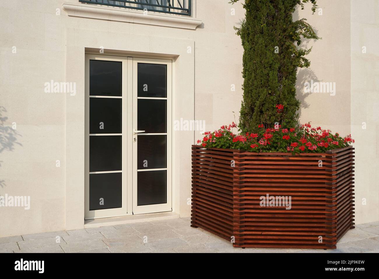 Beigefarbene pvc-Tür mit Glas an der Fassade eines modernen Gebäudes. Stockfoto