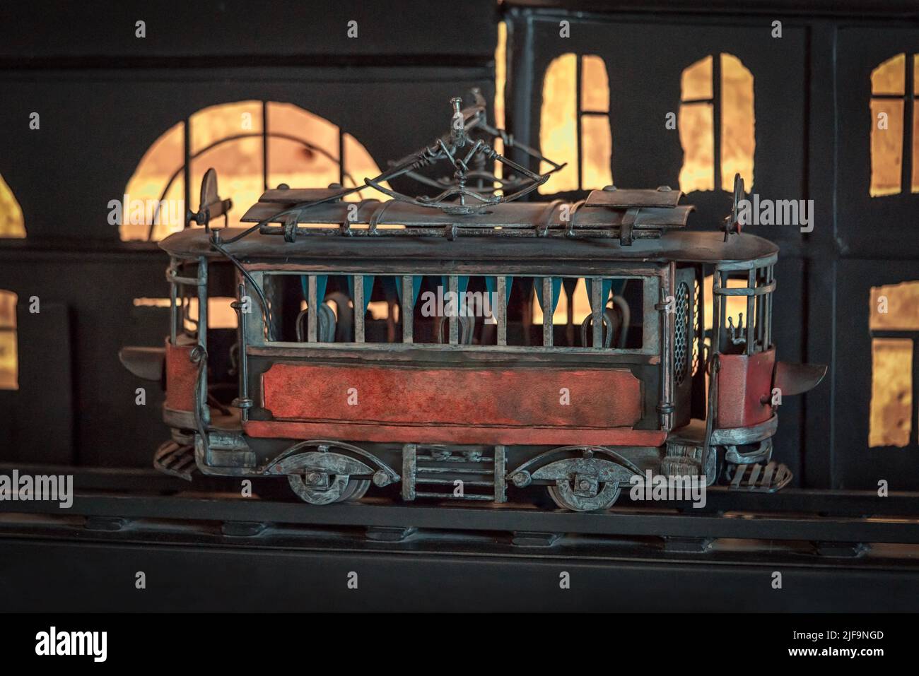 Vintage Tram Spielzeug in der Nacht vor beleuchteten Fenstern Stockfoto