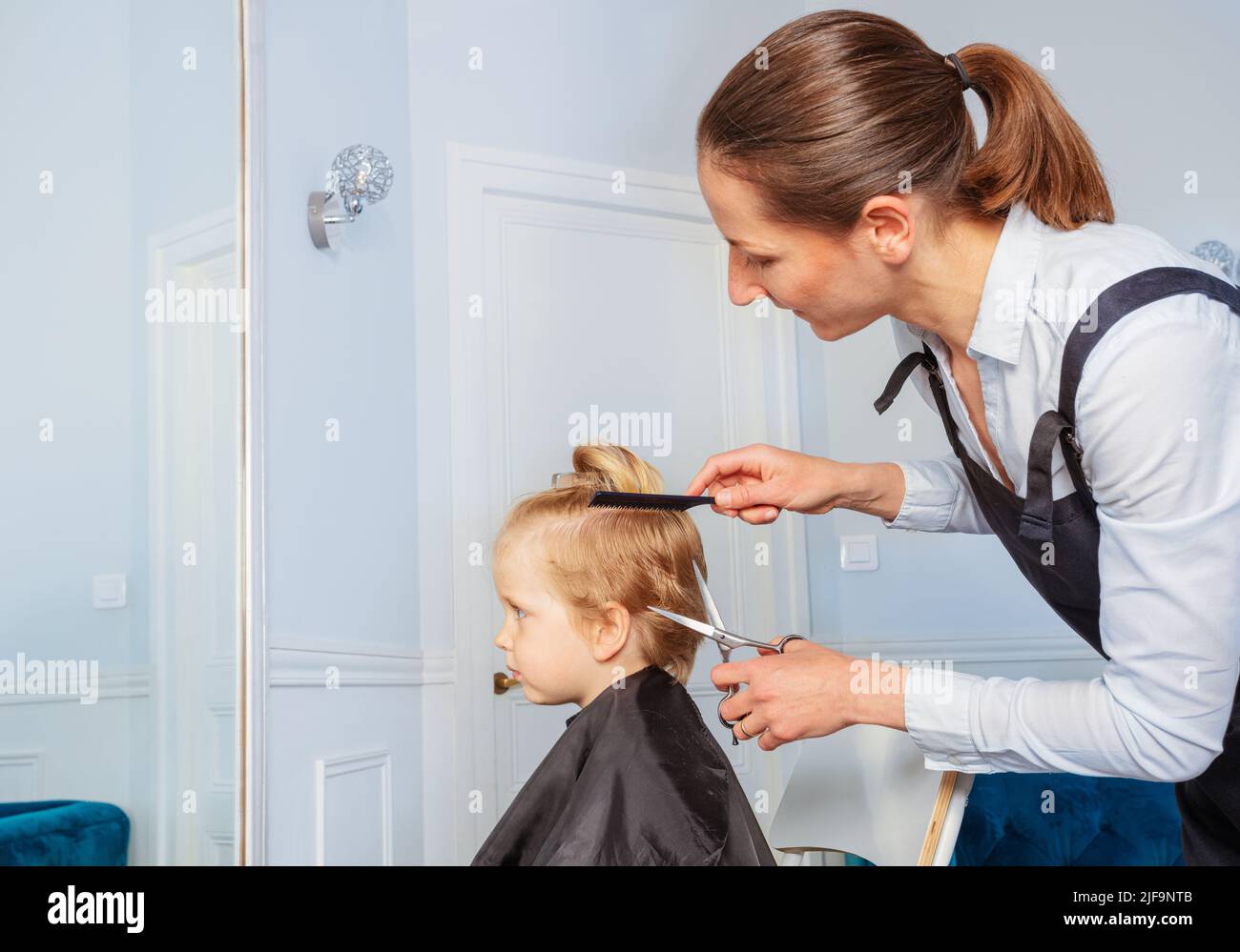 Junge erhalten Frisur bei einem professionellen Friseursalon Stockfoto