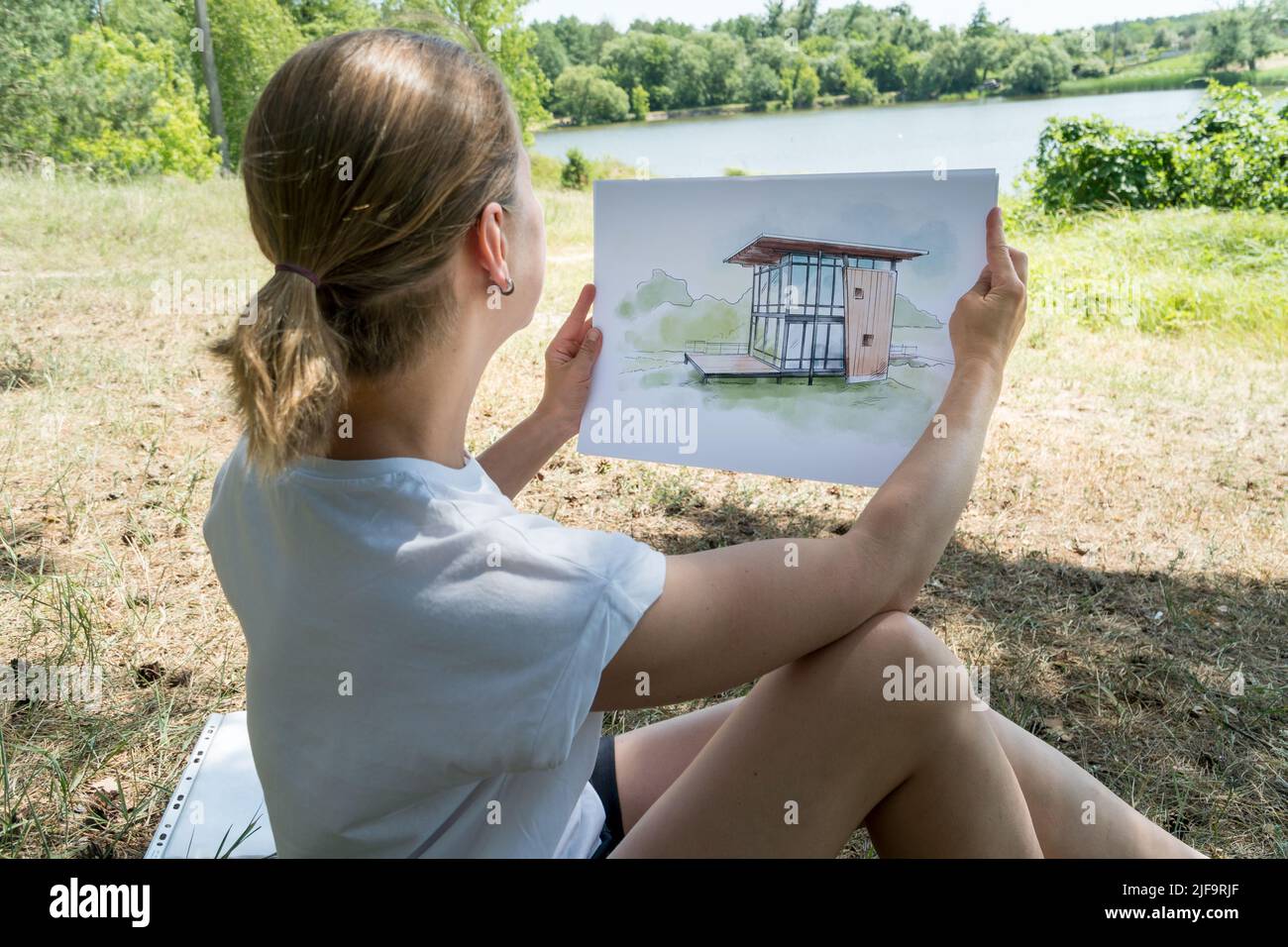 Zeitgenössisches Hausdesign Handgezeichnete Skizze in den Händen von Architekt. Architektonisches Designkonzept Stockfoto