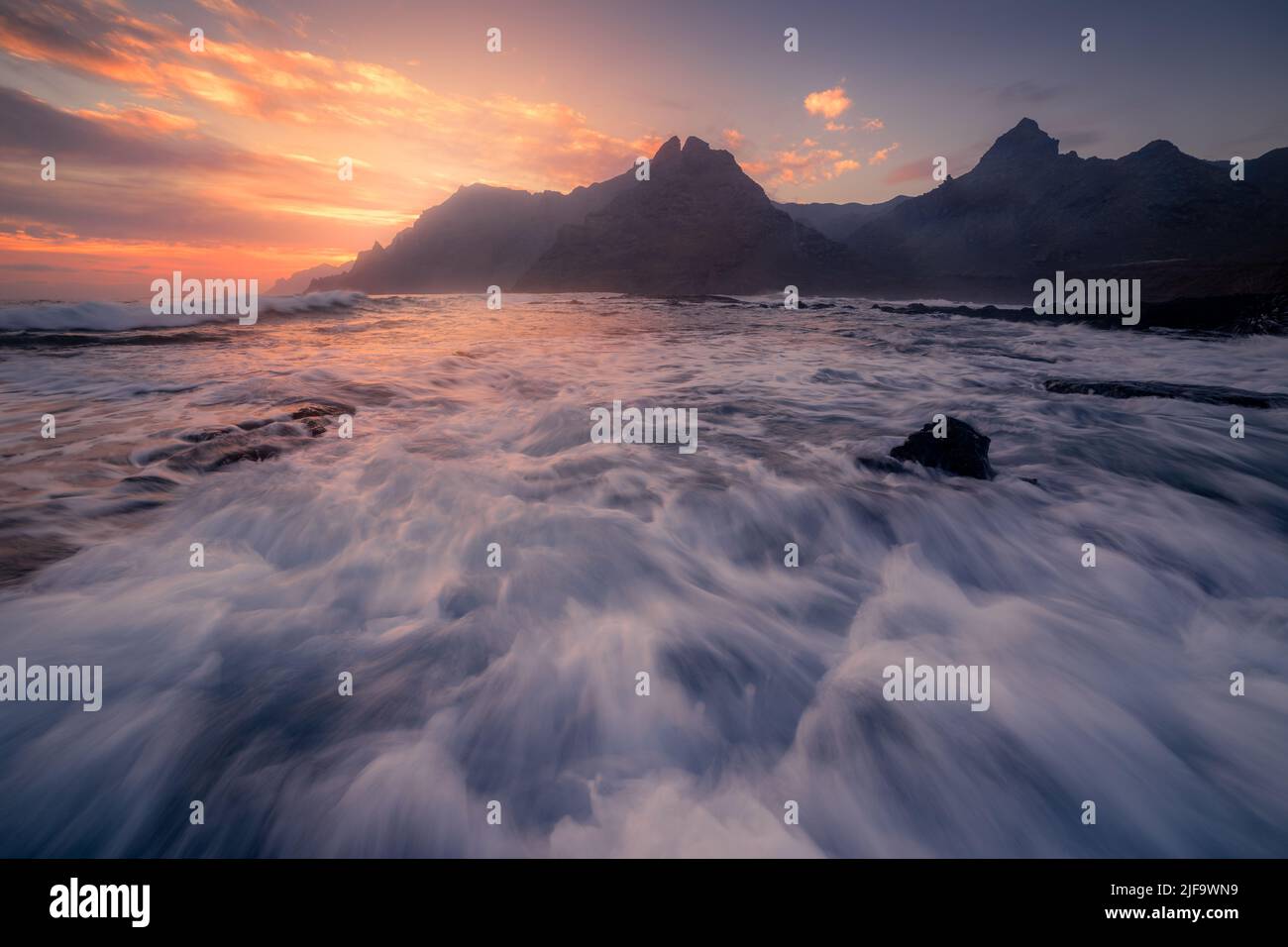 Punta del Hidalgo Meereslandschaft bei Sonnenaufgang mit den Anaga Bergen im Hintergrund. La Laguna. Teneriffa. Kanarische Inseln Stockfoto