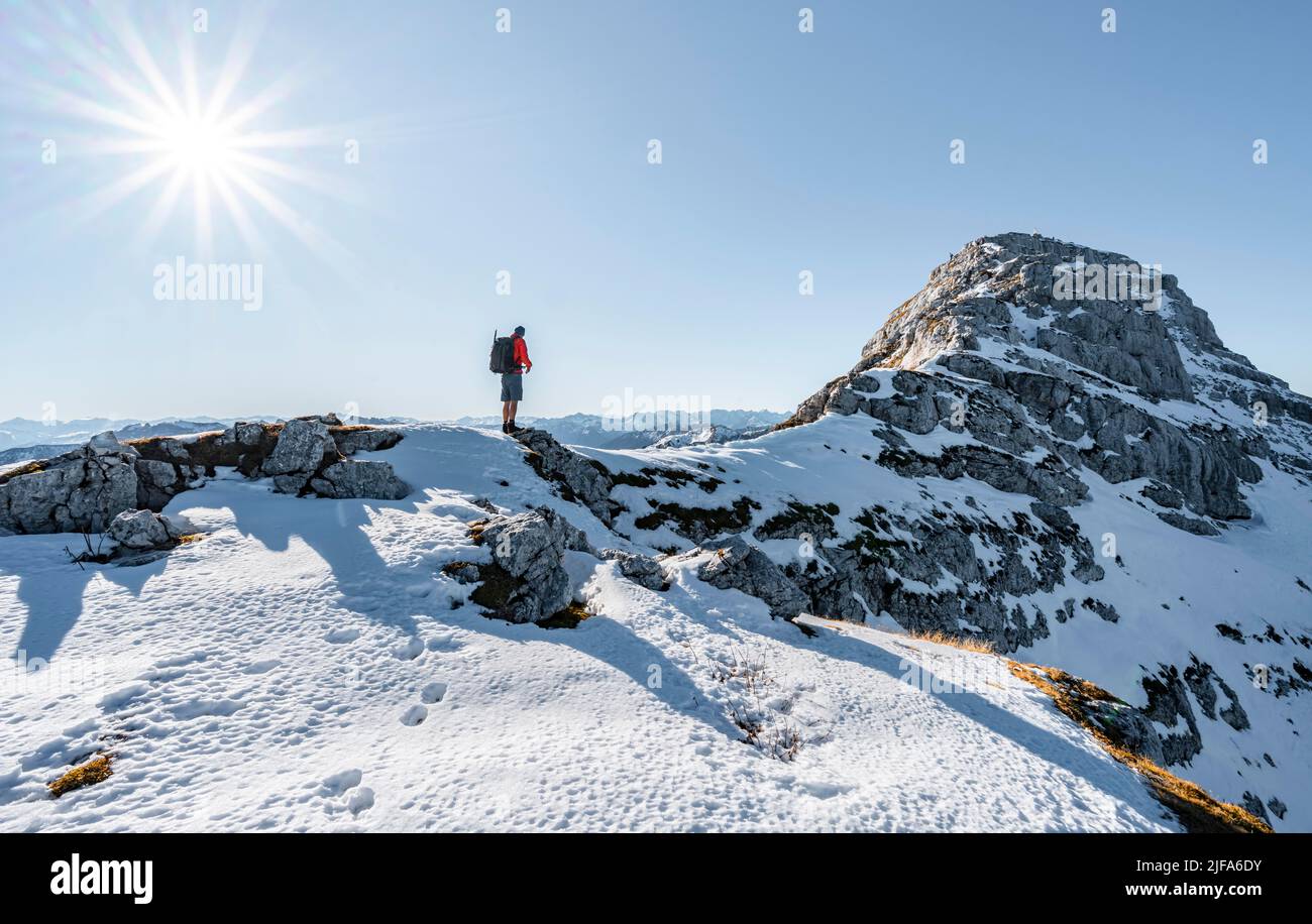 Bergsteiger auf dem felsigen Gipfelgrat mit Herbstschnee, Wanderweg nach Guffert, Sonnenreflex, Brandenberger Alpen, Tirol, Österreich Stockfoto