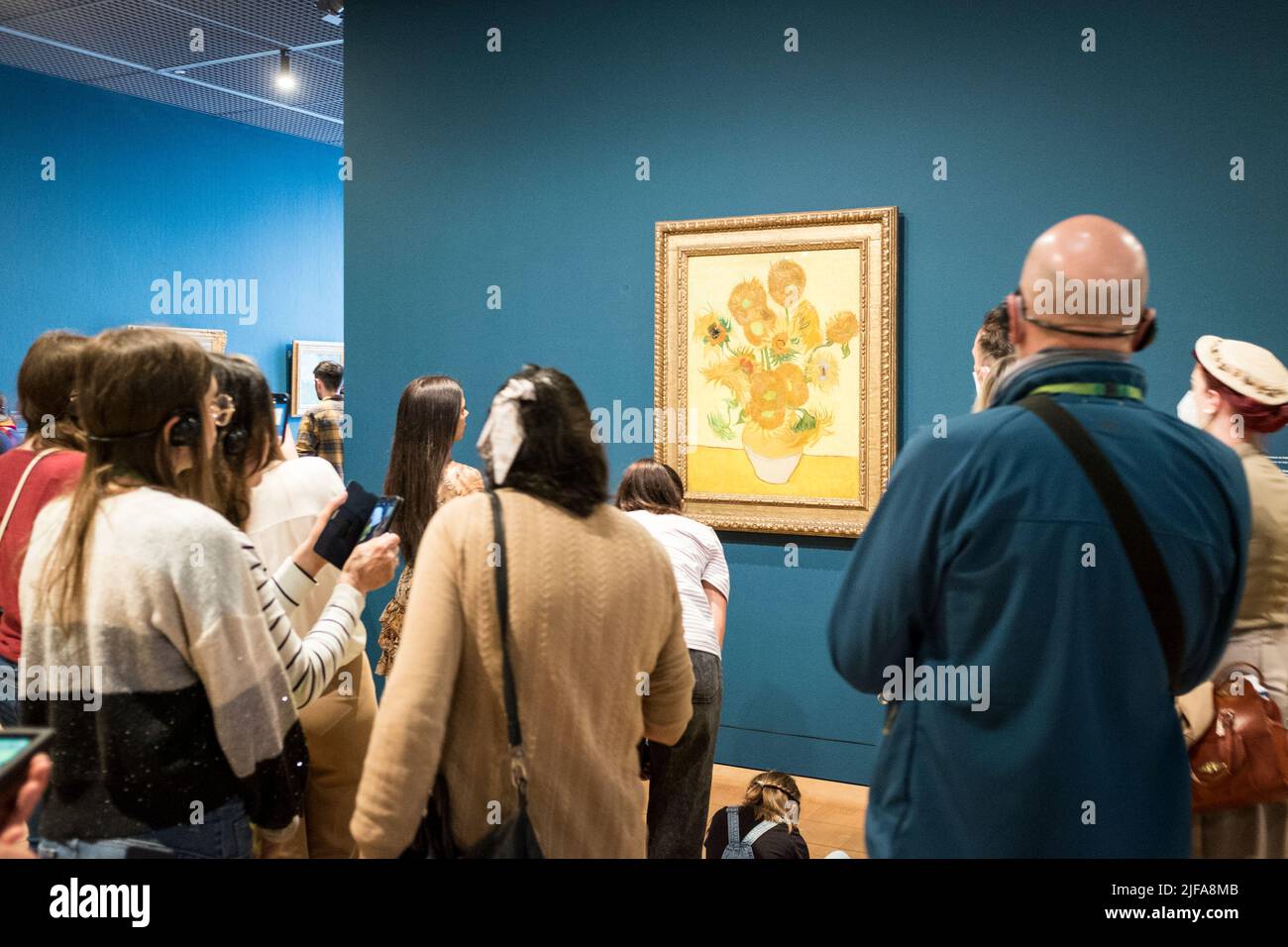 Besucher bewundern das Gemälde Sonnenblumen von Vincent Van Gogh im Van Gogh Museum in Amsterdam, Niederlande Stockfoto