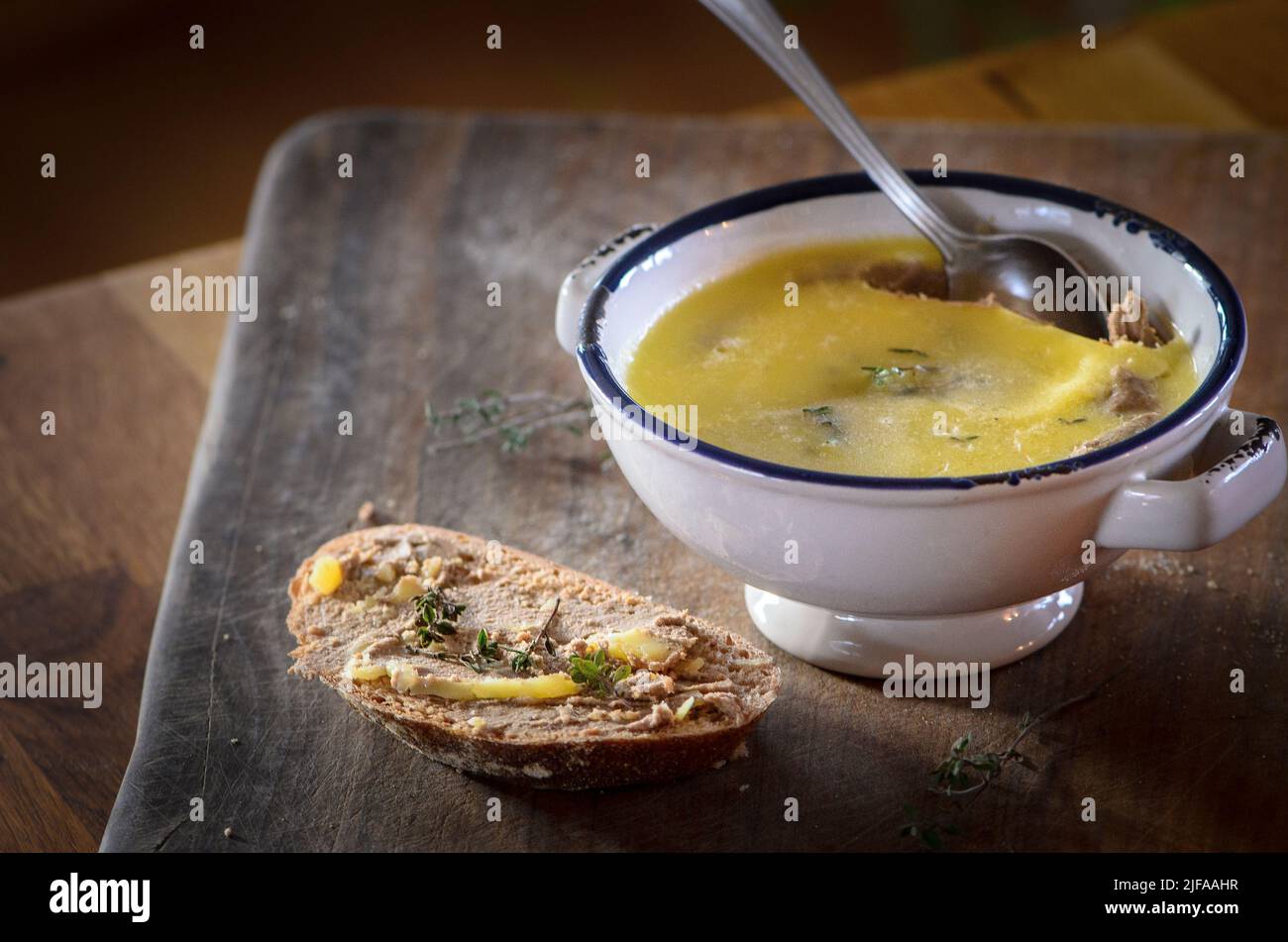 Hühnerleber in eine Schüssel geben und auf einer Brotscheibe verteilen Stockfoto