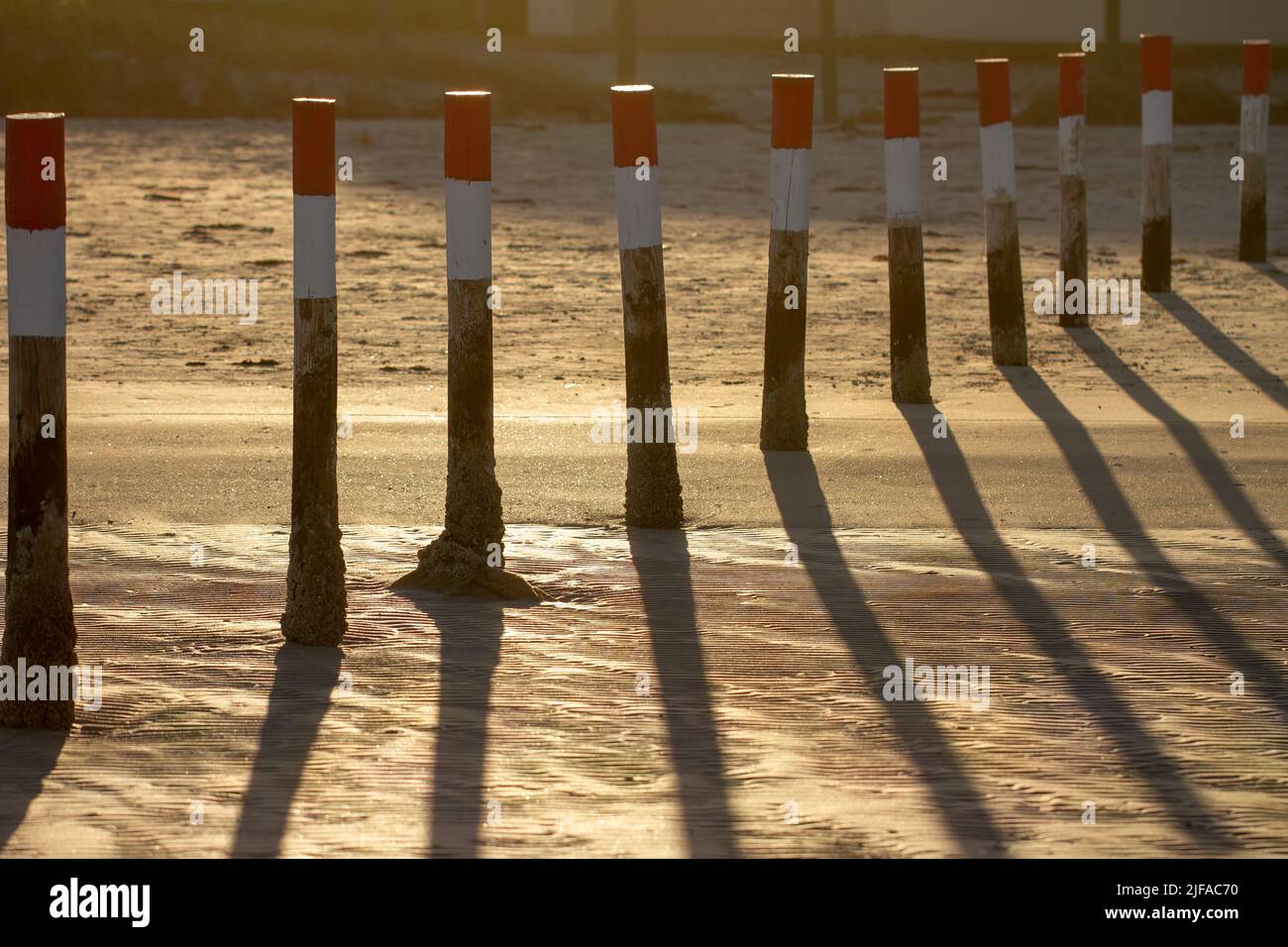 Rot-weiß lackierte Holzpollenmarkierungen in der Lagune. Stockfoto