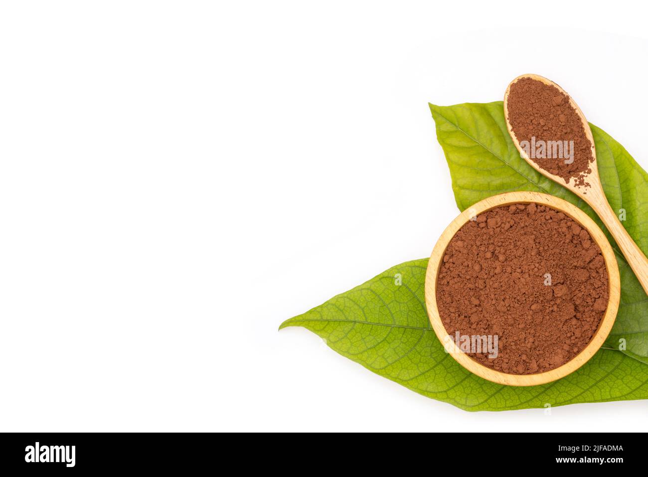 Draufsicht Haufen Kakaopulver in Holzlöffel und grünem Blatt isoliert auf weißem Hintergrund Stockfoto
