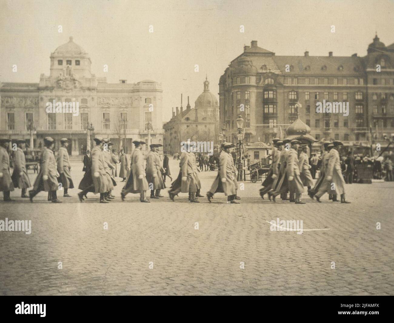 Soldaten der CFFICERSCUSEN 1916-1917 an der Militäruniversität Karlberg marschiert gegen Nybrokajen. Das Royal Dramatic Theatre ist im Hintergrund zu sehen - Dramaten. Stockfoto