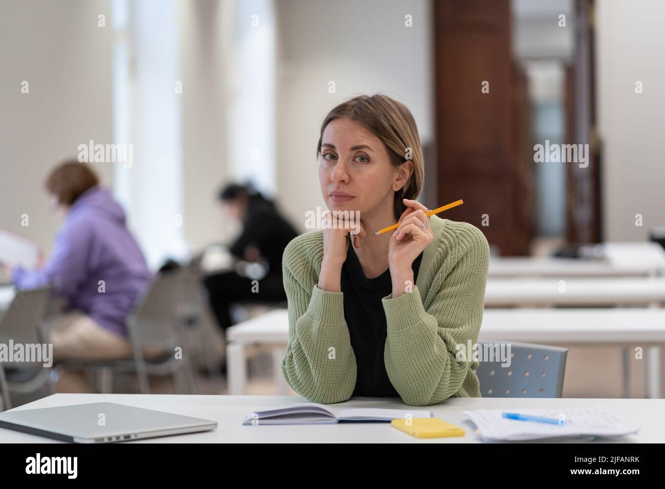 Porträt einer nachdenklichen fokussierten Frau mittleren Alters reifen weiblichen Studentin in Bibliothek Innenraum Stockfoto