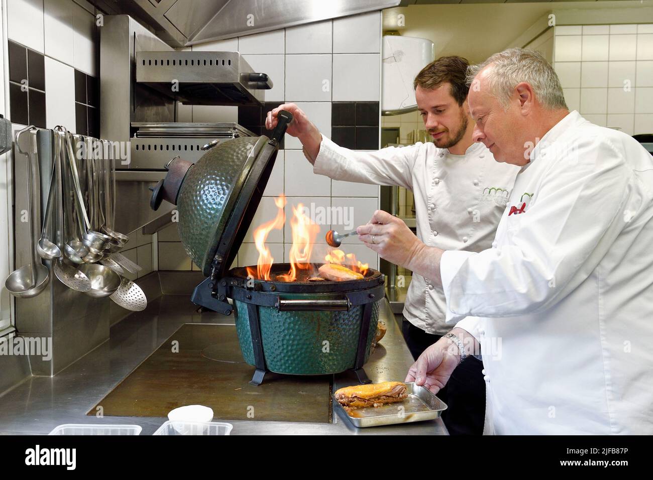 Frankreich, Charente, Bourg-Charente, Restaurant La Ribaudière, Michelin-Sternekoch Thierry Verrat und sein Sohn Julien, Zubereitung von Barbezieux-Geflügel in 2 Garzeiten, Konfit und gegrillt in Fass Holz Stockfoto