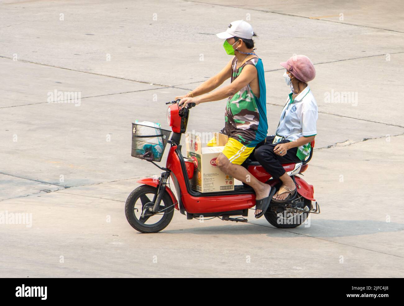 SAMUT PRAKAN, THAILAND, APR 07 2022, Ein Mann fährt mit einer Frau auf einem elektrischen Zweisitzer-Roller Stockfoto