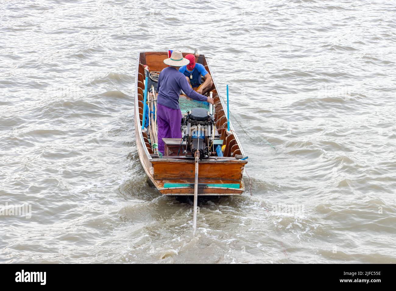 Asiatische Fischer segeln auf einem Boot und werfen ihre Netze ins Wasser Stockfoto