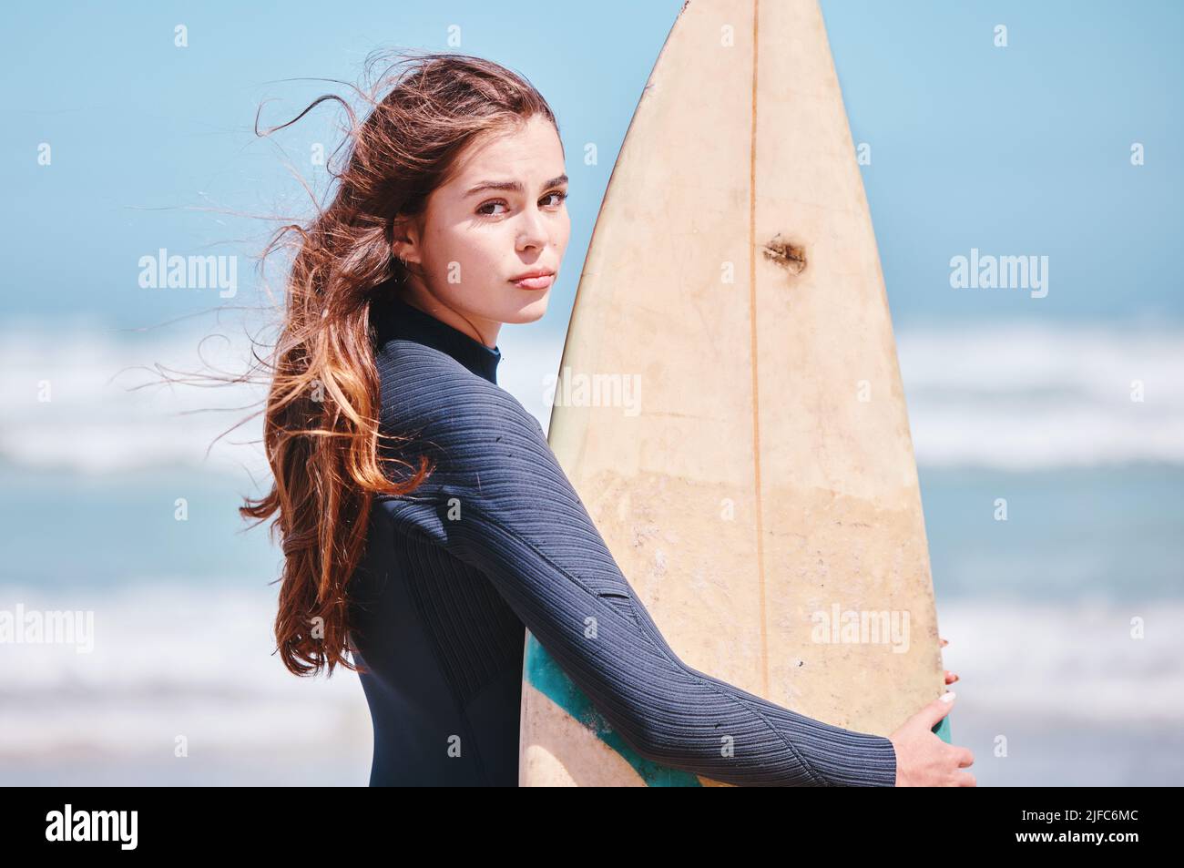 Porträt einer jungen kaukasischen Frau, die im Urlaub ein Surfbrett am Strand hält. Schöne Frau genießen das Wochenende und bleiben fit und mit ihr Stockfoto