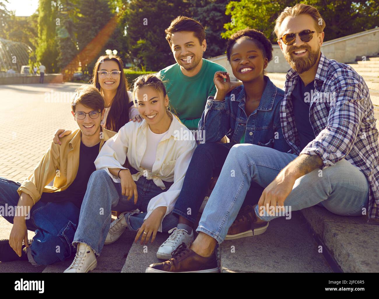 Porträt von unbeschwerten fröhlichen und freundlichen multirassischen Männern und Frauen auf dem Hintergrund des Stadtparks. Stockfoto