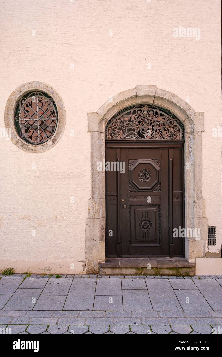 Kunstvoll gearbeitete Rundbogentür in einem historischen Gebäude am Manghaus-Platz in der Altstadt von Memmingen im Niederallgäu, Bayern, Deutschland. Stockfoto
