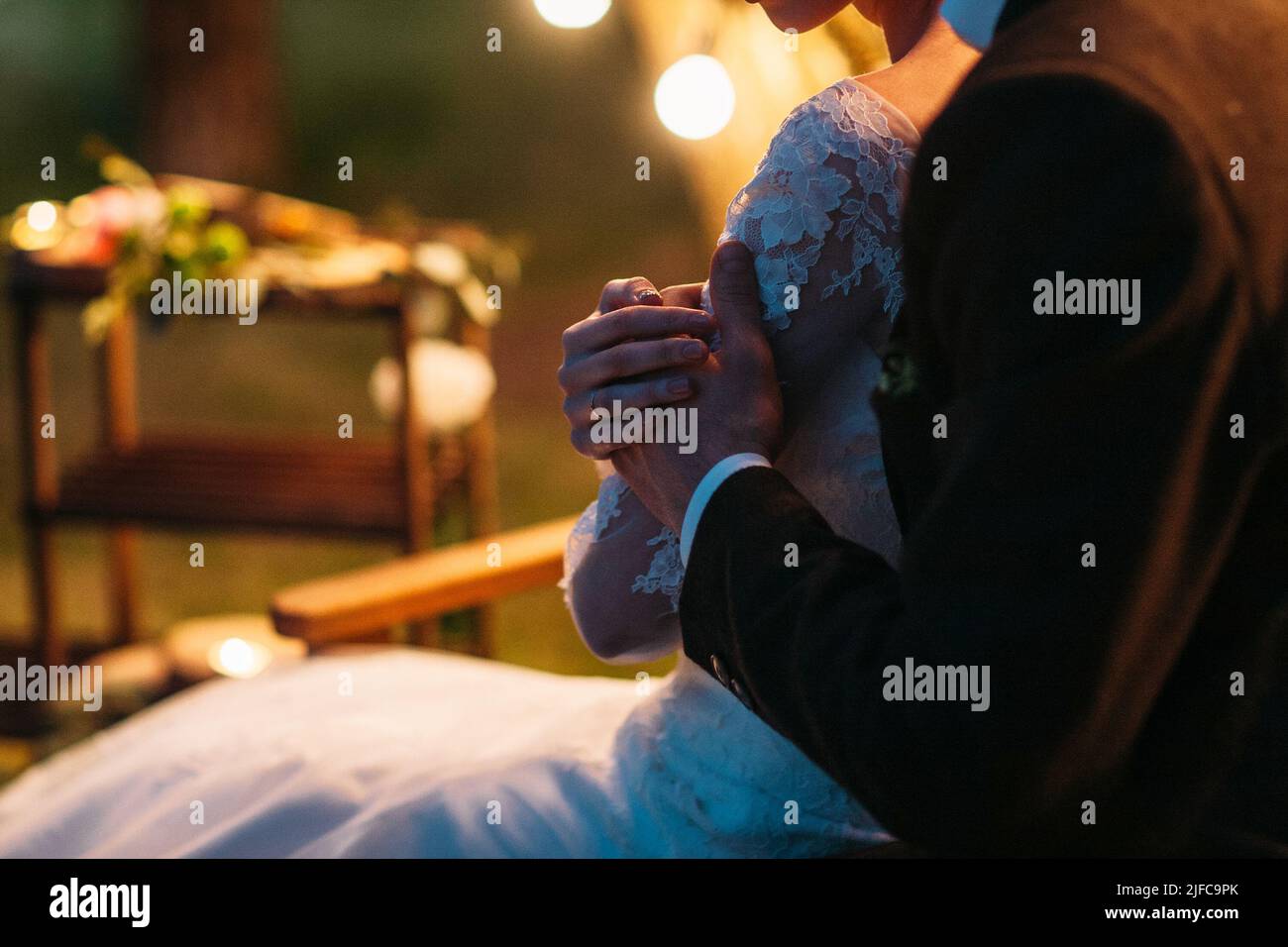 Braut und Bräutigam umarmen sich in sanftem Abendlicht Stockfoto