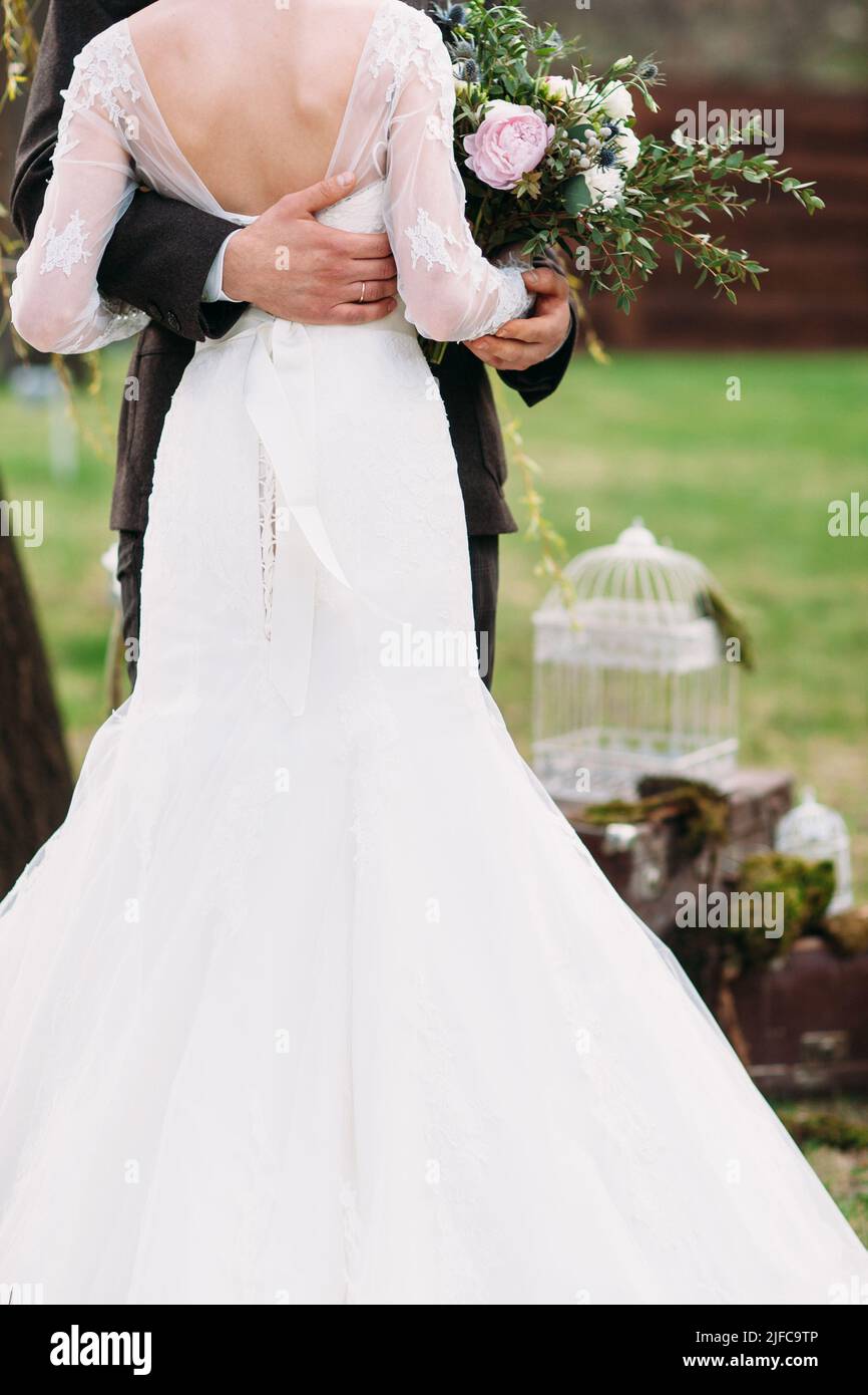Schöne Braut steht mit Bräutigam in Umarmungen Stockfoto