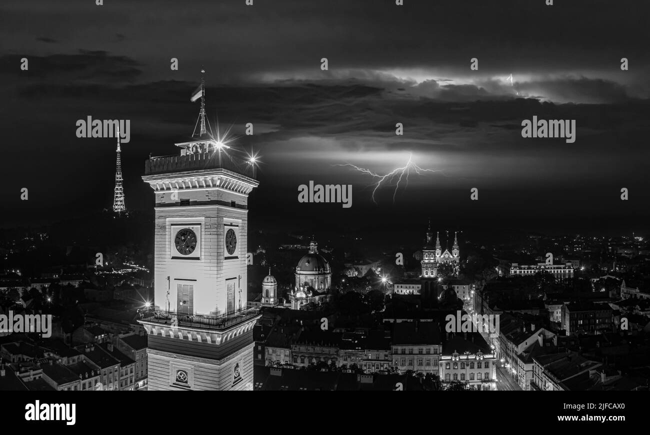 Luftaufnahme des Rathauses von Lviv in der Nacht von der Drohne mit Blitz am Himmel Stockfoto